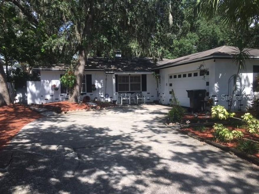 NO HOA! Must see this 3 BR 2 BA single family residence in Brandon, FL with attached 2-car garage! This solid concrete block construction home features a split bedroom plan, laminate floors in bedrooms and tile floors throughout the main areas. The spacious open-concept kitchen, living, and dining room arrangement creates a welcoming flow, highlighted by a beautiful wood-burning fireplace and a large window that fills the space with natural light. The west-facing property provides warm, golden light and beautiful sunset views, while its location on a quiet street offers safety and peace of mind. A small garden in the front yard adds charming curb appeal, complemented by a stunning mature palm tree that enhances the property’s character. Step outside to enjoy the beautiful outdoor lounge area on the open patio, complete with chain link fencing and rolled bamboo privacy panels, all overlooking a lush backyard filled with palm trees, vibrant plants, and greenery. A screened patio adds even more space for relaxing or entertaining.  All appliances, including washer and dryer, are included, making this home truly move-in ready. With short-term leases allowed, it’s a fantastic investment opportunity as well as a personal residence. Seller financing available. Do not wait, it will not last long!