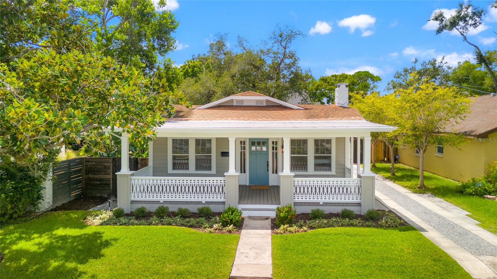 Welcome to Ridgewood Park: Tampa’s hottest and fastest-evolving neighborhood, offering Hyde Park elegance & charm with unbeatable access to the Riverwalk and Armature Works. This beautifully restored 3BR/2BA bungalow features a sweeping front porch, new luxury plank floors, fresh paint inside and out and lush landscaping. The spacious family room showcases a white brick fireplace, built-in bookcases, and decorative sconces, while the dining room shines with wainscoting and a soft-gold chandelier. The gourmet kitchen boasts custom cabinetry, granite countertops, backsplash, gas range, large island with breakfast bar, built-in bar with wine racks, and a sleek bay window with herb shelving. A laundry room with washer/dryer is included in this single story. The fully fenced, private backyard offers a rear wood deck and is a landscaped oasis with St. Augustine grass, blooming ixora, Silver buttonwood trees, and a Key lime tree. Detached garage with storage opens to a paved rear alley for easy bike or golf cart access. Steps to Michelin-starred dining, Ulele, Tampa’s newest Publix, and Julian B. Lane Park with pickleball, splash pad, and year round events & festivals.