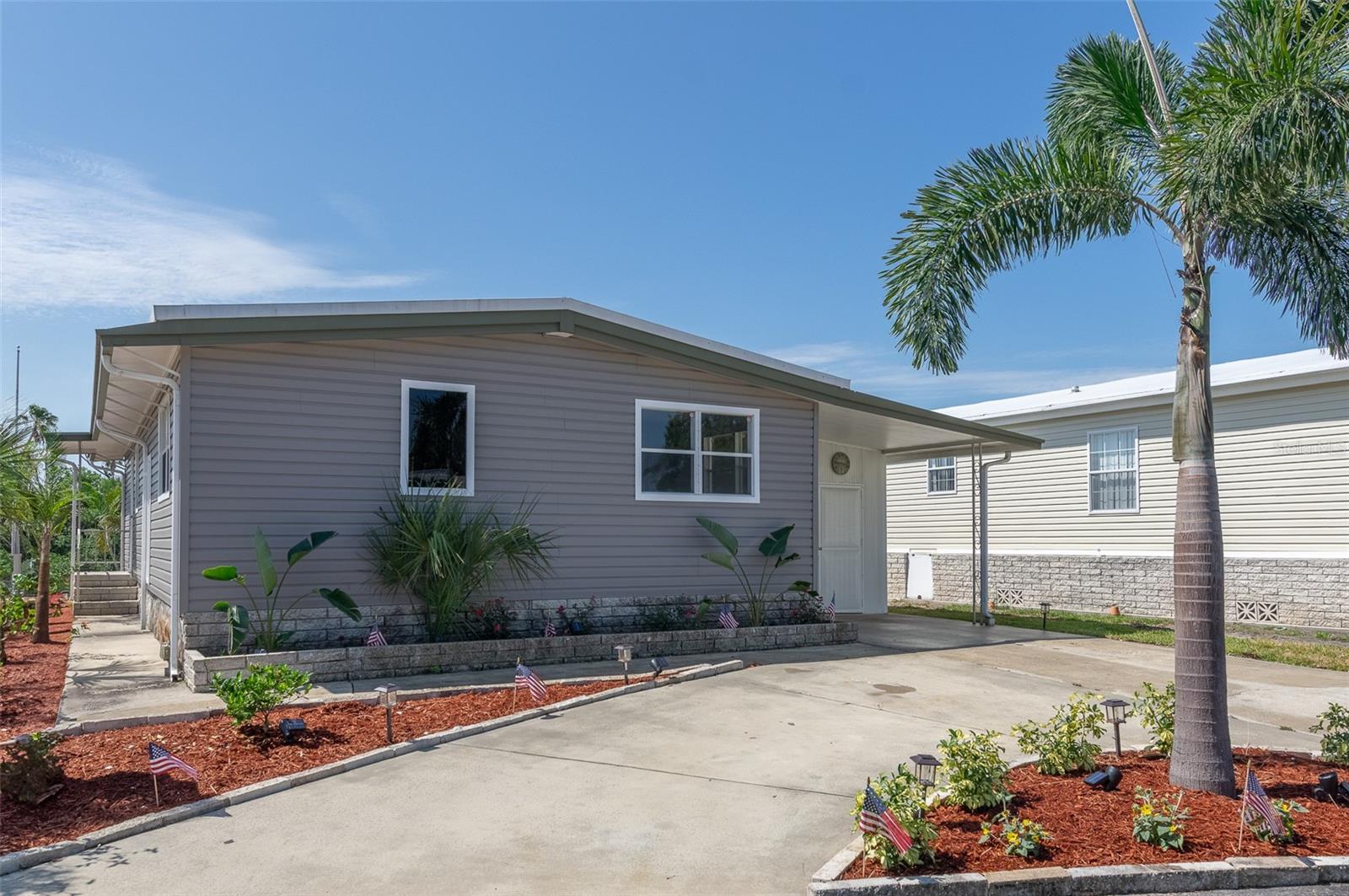 Live in the Florida lifestyle in this beautifully remodeled waterfront home. As you step into the inviting screened porch, you are greeted by serene waterfront views. This spacious 3-bedroom. 2-bath home features new stainless appliances, updated cabinets, a large custom island, solid granite surface countertops, and new ductwork. Enjoy plenty of parking for up to 4 cars. No interior flooding in 2024 hurricanes, providing peace of mind. The price includes a share of the lot and ownership in the co-op. Located in Americana Cover, a vibrant 55+ waterfront community, your only 10 minutes to downtown St. Petersburg and 25 minutes to Tampa International Airport. Don't miss your chance to own a waterfront property at an incredible price.