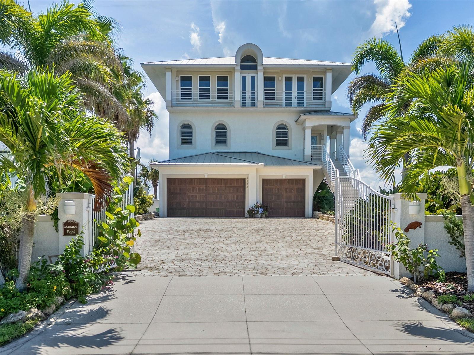 Manatee Point – Where Nature Paints the Hours – is a rare coastal estate that seamlessly blends refined luxury with the raw beauty of Florida’s most captivating landscapes. This 4-bedroom, 3.5-bath residence encompasses 5,531 square feet of living space, artfully designed to capture sweeping views of both the Indian River & the Atlantic Ocean. Nestled in the tranquil Bethune Beach enclave of New Smyrna Beach, the property offers an unparalleled lifestyle at the meeting point of elegance, comfort, & unspoiled nature. A private covered dock grants direct access to boating, fishing, & endless waterway exploration. Set along the Indian River, this home is more than a residence—it is a sanctuary. Each day begins with the sight of golden sunrises glistening across the water & ends with dramatic, color-soaked sunsets mirrored in the tranquil river. Dolphins leap playfully while manatees drift silently in the quiet cove, just steps from your backyard. Elegant herons, pelicans, & egrets arrive daily, transforming your waterfront into a living canvas of natural wonder. To the east, the Atlantic Ocean is only a block away, ensuring the sea is always within reach. Every room is oriented to celebrate these vistas, from the owner’s suite & formal dining room to the glass-enclosed office & expansive living spaces. Built with poured concrete for strength & permanence, the home was crafted with soaring ceilings, rich wood & marble floors, & an architectural floating staircase. A three-stop elevator ensures convenience, while walls of glass frame panoramic 180° views that blur the boundaries between indoors & out. At the heart of the home, a chef’s kitchen awaits, complete with quartz countertops, a gas range, butler’s pantry, & designer lighting. The primary suite serves as a private retreat, with dual walk-in closets, a coffee bar, & a spa-inspired bath featuring a Jacuzzi tub overlooking the river. Additional comforts include a second-floor laundry with granite counters, outfitted closets with custom storage, & a 969-square-foot three-car garage. On the first level, a private guest suite with its own living room & bath opens directly to the pool & dock, offering an ideal escape for family or visitors. The outdoor lifestyle here is second to none. A sparkling pool with waterfall Jacuzzi overlooks the river, while multiple balconies invite both sunrise coffee & sunset cocktails. Paddleboard or kayak from your backyard, stroll to world-class surf breaks, or fish the legendary waters of Mosquito Lagoon. Lush landscaping with mature palms enhances the sense of privacy & tropical charm. Modern upgrades include a whole-house water filtration system, impact-rated glass doors & windows (2018), nineteen new architectural windows (2025), two Lennox HVAC systems with transferable warranties (2024) & a durable metal roof (2014). These features ensure both luxury & peace of mind. Beyond your gates, New Smyrna Beach offers vibrant cultural & recreational opportunities. Stroll to the no-drive beach, kayak through Canaveral National Seashore, or watch rocket launches from nearby Kennedy Space Center. Just minutes away, Flagler Ave & Canal Street deliver boutique shopping, dining, & art. Championship golf, Daytona Speedway, & Orlando’s theme parks & international airport are within easy reach. More than a home, Manatee Point is a private waterfront sanctuary—an inspiring retreat where natural beauty & refined living converge in one extraordinary address.