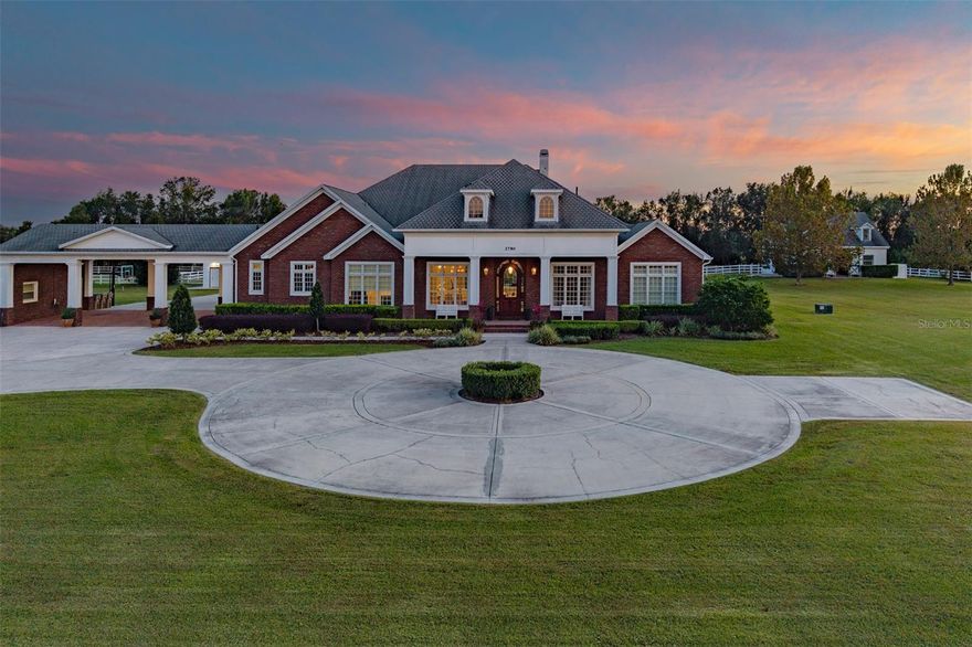 Discover the epitome of equestrian luxury with this pristine 5.85-acre estate, featuring a state-of-the-art 4-stall barn, premier riding ring, and a meticulously designed custom home & guest house. Strategically located in Central Florida, just minutes from major roadways and an easy location to all the major horse shows & events Florida offers.
This exceptional estate’s main residence boasts 8,261 sf of luxury living with 7 bedrooms, 5 bathrooms, all carefully renovated with designer selections. Gorgeous formal dining room can seat 12, perfect for those special holidays. An incredible chef’s kitchen features a bar-style center island, all opening to large gathering space, which features a gorgeous fireplace with custom-built mantle. The chef’s kitchen is home to updated stainless appliances, custom wood cabinetry, center island with sink and bar seating, granite counters, hidden pantry, double refrigerator & freezer, and generous counter space to spread out. The back of house has views from an incredible window and door bank, which allows beautiful ambient light through the house and overlooks the outdoor resort-style pool and entertaining area. This is the home your friends and family will gather in and want to stay! The home office or flex room is designed for a golf simulator; practice your game while taking those work calls. As you step outside, an outdoor paradise awaits, where the pool takes center stage for a “stay-cation” at home with a lazy river, spa, pool cabana & firepit, and deck that wraps the pool, providing plenty of space for a large crowd. The covered lanai extends across the back and includes a fully appointed summer kitchen with room for al fresco dining space to soak in the Florida weather.
Primary suite with spa-like bathroom, which includes his and her vanities, steam station of clothing, makeup vanity, double head shower, jetted tub, and built-in jewelry cabinet. 2 of the 7 bedrooms are upstairs with great landing area. Home has terrific storage and every detail accounted for.
The equestrian amenities are designed for horse lovers and include 4 stables, a tack room, sliding doors on 3 sides, an incredible 1,800 sf garage with roll-up doors for ease of parking your vehicles and toys, as well as a Tesla charger. A 1,324 sf Porte-cochere connects the main house to guest house. Guest house or in-law suite is 1,620 sf, is 3 bedrooms, 2 baths, providing privacy for all. The function of this property is designed for the serious equestrian in a perfect serene location while being close to a city lifestyle. Other features of the unique property include whole house generator (Generac), inside laundry organization center with pet washing area, plantation shutters, Icynene insulation, irrigation (not in pastures), crown molding and chair rail, central vacuum system, in-floor outlets, tankless water heater, garage roof 2022, upstairs AC 2023, and more. This property was carefully designed with the highest quality architectural details and craftsmanship; expect to be impressed.
If the equestrian lifestyle is what you are looking for, this location and property cannot be matched. In the heart of Central Florida, it is close to the attractions, airports, downtown Orlando, and more. Inquire about a private tour of this special place.