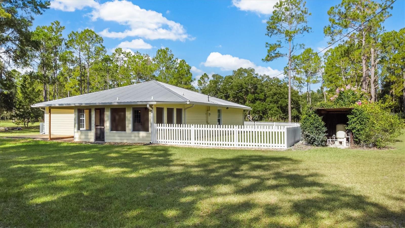Country Living at its finest. Freshly painted and updated, split plan, 3 bedroom/ 2 bath, concrete block / Hardi board home with metal roof on 7.82 acres. Recently updated kitchen featuring hickory cabinets, black stainless-steel appliances, solid surface Corian countertops, and pressed aluminum backsplash. The bedrooms are of ample size and have plenty of closet storage along with crown molding. Large Livingroom sits in the front of the home and opens into a dining room area next to the kitchen. The home also has a screened in porch and a deck area for grilling. RV hangar with power for a large 5th wheel style RV and a workshop with power and car ports. An additional storage building is available to store a tractor or another car. A greenhouse is also included with the property. Meyer Lemon, orange, and fig trees have been planted. Other updates include a new well approx. three years ago, Roof in 2017 and the AC in 2010. Schedule your showing today.