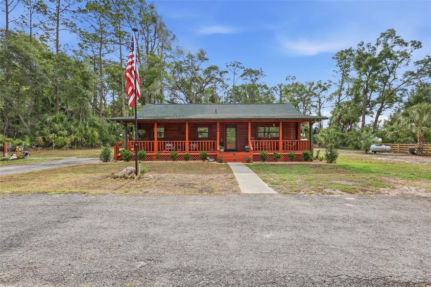 Picture an authentic 3-bed, 2-bath log cabin tucked away from the world, where the scent of fresh pine and the stillness of the Florida countryside invite you to sit for a while on the front porch and simply breathe! This 1-acre property in Chiefland’s Enchanted Forest stands as a masterclass in rustic durability, fortified by a 2025 roof, a 2-year-old water heater, and a recently serviced HVAC system that ensures total modern comfort within its timber walls. Crossing the threshold, you find yourself under the dramatic height of vaulted wood ceilings as the home unfolds into a warm interior where luxury vinyl plank flooring and a custom brick feature wall connect the spacious living area to a kitchen finished with tile flooring, wood cabinetry, newer granite countertops, and 2024 stainless steel appliances. The thoughtful layout carries you through three cozy bedrooms, including a spacious primary suite with an ensuite bathroom and a former porch that has been beautifully enclosed with closets to serve as a third bedroom. Both updated bathrooms feature gray rectangular tile flooring, newer vanities, and white painted wood ceilings. The magic extends to the grounds, where a fully fenced yard — with a property line extending approximately 40 feet beyond the back fence — gives way to a powerhouse workspace consisting of two permitted structures: a dedicated 20x20 workshop and a new 30x40 structure engineered with 12-foot ceilings and 6-inch concrete floors to support a vehicle lift. This peaceful setting offers the freedom of no HOA. You also remain perfectly connected to the community, with Chiefland Elementary, Middle, and High Schools all just a short 10-minute drive away. Adventure is right in your backyard with the crystal-clear waters of Manatee Springs State Park nearby for unrivaled snorkeling and swimming, while the paved Nature Coast State Trail offers miles of scenic hiking and biking. Even with this secluded feel, the convenience of the local shopping center and a variety of dining options are just 5 miles from your front door. Don’t just dream of a nature-focused lifestyle—schedule a private tour and start your next chapter in a charming log cabin in the woods!