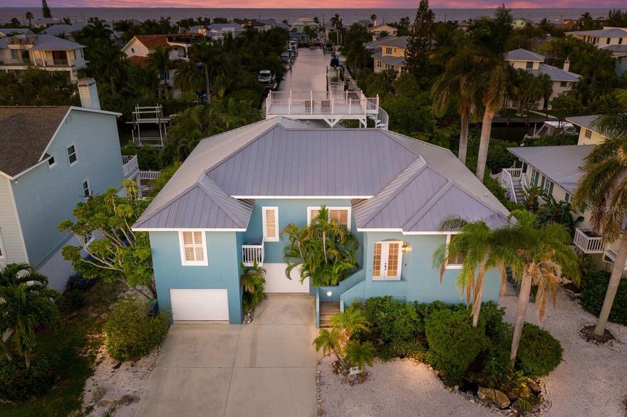 Welcome to Blue Turtle, this beautiful waterfront pool home is nestled at the quaint north end of Anna Maria Island. The Blue Turtle boasts panoramic views of the Gulf of Mexico and the Skyway Bridge from the large roof top deck.  A fabulous 4 bedroom 3.5 bath home offering a split floor plan with extra large kitchen, large laundry room, family room combination, living room, dining room, wood scraped floors in the bedrooms and family room, tile, high ceilings, large master bedroom and bath. There is a beautiful deck off the back of the home overlooking the yard and the canal.  The home also offers a very large over sized garage with enough space for 4 cars and a golf cart, game room , pool bath, new deck, resurfaced pool, hot tub, new roof 2019, AC 2016, new dock and new 10,000 lb. boat lift installed in 2023.  All of these fabulous features and just a short walk to beach, Pine Ave, the Anna Maria Community Center, shops and restaurants.  This home is being sold turnkey furnished with rentals in place, this home has so much space and offers the next homeowner a wonderful island oasis with income.