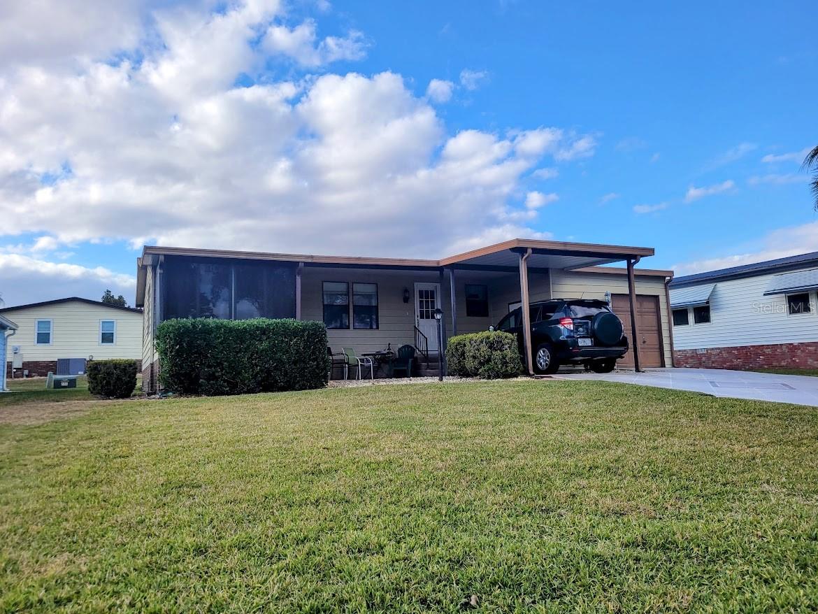 This owner says, they need to sell their home! It comes complete with a one car carport and a golf cart garage that has a workshop, storage shelves and plenty of extra room more. The washer and dryer are located in the golf cart garage and the covered front patio invies guests into the front Florida room with a portable cooling system. Enter into the main house through sliding glass doors to the open living room with vaulted ceilings and a wall size mirror. There's new laminate flooring and the newer furniture are negotiable to stay with the home. There's a pass through window from the kitchen to the dining area. There's a slide away screen door at the kitchen entry. In the kitchen, a center island breakfast bar, a closet pantry, double sinks, a dishwasher and smoothtop stove add to the mini chef's kitchen. A new HVAC system was added in 2025. There's a full bath with tub shower unit, and a dressing table with updated sink. The primary bedroom has a walk in closet and newer window that looks out to the spacious back yard. The guest bedroom has an ensuite half bath that could be expanded to add a shower. The wall closet has extra top storage and plenty of space for more. The owner is currently boxing up the many treasures so bring your vision of the future of owning your own affordable homine the Villages. There is no bond. The home is located on a cul de sac lot with lots of elbow room. This home does need a roof and seller will give an allowance at closing for a replacement roof.