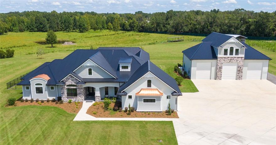 Welcome to this architectural masterpiece, a custom built luxury modern home from 2021. Nestled on a sprawling 21+ acres of gated property, this magnificent estate was crafted by a local luxury homebuilder for his personal residence, ensuring every feature is meticulously designed and of the highest quality. ** The property is expansive - boasting over 15,000 sq ft under roof and featuring three separate living spaces, six bedrooms, five and a half bathrooms, and three full kitchens. The principal residence spans 4,574 square feet, including four bedrooms and a poolside cabana house with its own kitchen and private bathroom. Every inch of this exquisite estate is designed for luxury, comfort, energy efficiency and superior entertainment.** The outdoor space is nothing short of spectacular, with marble pavers surrounding the large heated saltwater pool and spa. The pool features a swim shelf with bubblers and a spill-over waterfall, creating a tranquil oasis. The pool is flanked by covered patio entertainment areas, complete with 12' tongue and groove detailed wood ceilings, an outdoor gas grill, and a pellet smoker area with a high-top leather granite island. For added convenience, a custom mosquito mister system keeps the property bug-free.**The main home's kitchen is an epicurean dream, featuring a backlit marble counter island, top-of-the-line Thermador appliances, a 6-burner gas grill, double oven, and a nugget ice machine. Beverage connoisseurs will appreciate the two wine refrigerators and four additional refrigerator/freezers.**The master suite serves as a tranquil retreat, boasting double walk-in closets, an attached sunroom that doubles as an office, and a built-in Thermador coffee maker. Beautifully positioned, the suite overlooks the stunning landscaped grounds and the serene pool area, offering a daily spectacle of beauty and tranquility.**Additional amenities throughout the home include a mud room, two pantries, private laundry room, impact windows with safety film, metal roof structure, icynene insulation, radiant barrier, and hardie board soffit, a commercial water purification system (water dispenser, pot filler & ice maker are all attached to the purification system) and an attached oversized 3-car garage for everyday vehicles with larger 8' doors.**The impressive 50 x 60 workshop is a marvel of design and functionality. With its soaring 16' ceilings and five 14' automatic roll-up doors, the space is more than just a workshop; it's an arena for creativity and productivity. It comes complete with RV hookups (all 3!), a wall-mounted pressure washer, and a second washer/dryer connection and more providing all the conveniences you might need. Above the garage, you'll find the third living space, a 1,000 sq ft apartment that can serve as an office or an ultimate man cave.**The estate is also equipped with two ponds for cattle and built-in irrigation as well as a full house generator, powered by a 1,000-gallon buried propane tank, can run the entire home for up to 21 days if needed.**This estate truly has it all - luxury, comfort, and functionality - all located in one of the most desired areas in all of central Florida. Contact the listing agent today for a tour or video to fully appreciate the magnificent details of this unique property. This estate is more than just a home; it's a lifestyle waiting to be embraced by its lucky new owners.