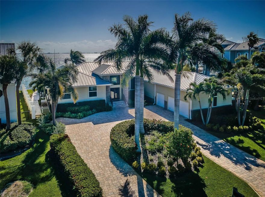 Under contract-accepting backup offers. THIS REMARKABLE 4 BEDROOM LUXURY RESIDENCE, WITH ITS IMPRESSIVE 155FT OF SEAWALL AND ASTOUNDING BACKYARD BOATING, DINING AND RECREATIONAL PARADISE, DELIVERS MAJESTIC OPEN WATER VIEWS OF THE SUNSHINE SKYWAY BRIDGE. Lushly landscaped with a finely-pavered circular driveway, rich flatstone  exterior finishes, 14ft-high covered entry and 15ft high foyer, welcome to a residence with dazzling unobstructed waterviews that span the width of this amazing home. A grand great room plan features 12ft-high vaulted ceilings, built-in entertainment center and surround sound. The exquisite chef’s kitchen boasts a wonderful island bar with beverage chiller/prep center, high-quality stainless-steel appliances including Subzero refrigeration, a custom pass-thru storage hutch, elegant granite surfaces/backsplash areas and extensive cabinetry storage. You’ll love the family room and its sweeping views of the waterfront. The gorgeous owner’s suite offers incredible water views, two roomy walk-in closets with closet systems, a private waterfront deck and dedicated access to the pool deck. Your owner’s bath is a pampering retreat with luxe free-standing soaking tub, glass-enclosed rain-shower with multiple shower heads, and two superb quartz vanities with a matching built-in linen/dresser. Second and third bedrooms are generously-sized with fine closet systems, while the second and third full baths are both gracefully in their appointments and tastefully-finished. The 4th bedroom is set up as an executive office with exceptional built-in furnishings. Step out back to a rare waterfront spectacle: The 370sqft covered lounging deck transitions to a stunning Pebbletec infinity pool/spa with in-pool lounging area and specialty waterfall effects, and built-in Tucci SS umbrella. Thick travertine pavers meander throughout the deck and sitting areas. The built-in luxury outdoor gas kitchen supports a dedicated built-in pool bar. Built-in gas firepit is complemented by a large built-in seating area. The composite boat dock setup is truly incredible, with 30K lb boat lift (accessible from three sides), 7K lb dual jetski platform lift, step-down area for kayak/paddleboard launch, mooring for a deep water cruiser, and extensive lighting, power and water. The list of features/capabilities of the outdoor waterfront area of this home make it an entertainment marvel. Exquisite marble floors, lavish woodworking, splendid specialty window treatments, whole-house water filtration/softening system, central vacuum, whole-house backup gas generator, extensive landscaping, 3 car garage with built in cabinetry and so much more. This is a magnificent home and extraordinary waterfront living experience in one of Florida’s best waterfront and boating communities. Flood policy is assumable at $1,170/yr. Dimensions are estimates, buyer to verify.