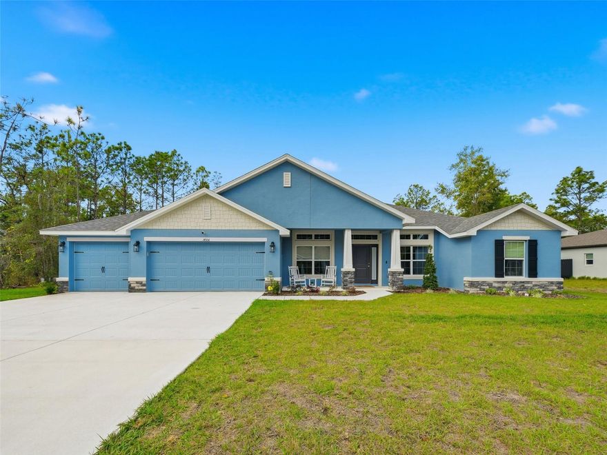One or more photo(s) has been virtually staged. Don't wait to build, RUN to 14351 Carolina Chickadee Rd, a beautifully maintained New residence set in the peaceful natural surroundings of Weeki Wachee in Hernando County, Florida. This better-than-new, barely lived-in 2,169 sq ft Adams Home showcases a timeless Craftsman elevation, offering four bedrooms, two bathrooms, and a spacious three-car garage, all located on a quiet dead-end street. The thoughtfully designed split-bedroom floor plan provides privacy and comfort, highlighted by a gracious owner's suite featuring a tray ceiling with crown molding and a spa-inspired bath complete with a separate tiled shower with lighting, a soothing garden tub framed by a fixed window, and dual vanities. The kitchen and baths are elegantly appointed with high-definition beveled-edge countertops, classic white Shaker cabinetry with pull bars, and stainless-steel appliances, including an upgraded Frigidaire French-door refrigerator. Tastefully upgraded lighting fixtures and ceiling fans enhance the home's refined, move-in-ready ambiance. Durable wood-look plank tile adds both beauty and practicality throughout all wet areas. Additional details include a welcoming entry foyer, stately double solid doors with sidelight glass opening to a voluminous living room. Spacious floorplan is open yet offer formal dining room and office/den/play or craft room, plus inside laundry room pre-plumbed for a utility sink, washer /dryer, two garage door openers with remote access, and a Vivint security system. Outdoor living is equally inviting, with a charming covered front porch and an expansive rear covered lanai overlooking a private, wooded, almost half-acre setting—an ideal backdrop for both quiet relaxation and elegant entertaining. Located in desirable Hernando County, residents enjoy easy access to the crystal-clear Weeki Wachee Springs, kayaking and paddleboarding on the Weeki Wachee River, nearby golf courses, nature preserves, and scenic hiking trails. Convenient access to shopping, dining, medical facilities, and major roadways makes commuting to Tampa, Clearwater, and the Gulf Coast beaches both easy and enjoyable. This exceptional home blends classic Craftsman charm with modern sophistication while offering a lifestyle rich in natural beauty, comfort, and convenience. Some photos virtually staged.