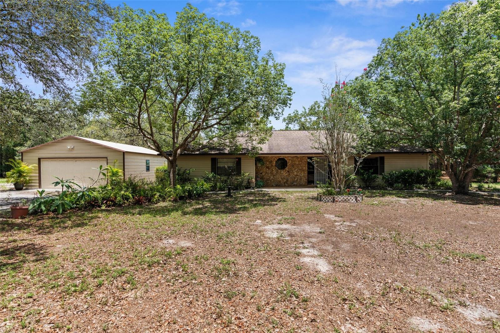 Welcome to your dream FULLY FENCED FAMILY COMPOUND!! This exceptional property features TWO FULL HOMES sitting on FIVE ACRES, multiple garages and a WORKSHOP, and a stunning POOL area—all set among beautiful, mature trees that give you a sense of peace and seclusion, while still being conveniently close to EVERYTHING you need. The primary home, built in 1989, offers 2,086 square feet of thoughtfully designed living space with THREE spacious bedrooms, TWO full bathrooms, a huge kitchen, an oversized dining room, and a massive laundry room. Every room is generously sized, offering an open and airy feel. Step outside to enjoy an in-ground pool, designed with shallow ends and a deeper center—great for relaxing or enjoying a game of volleyball (play pool). A covered lanai with a built-in propane grill extends the entertainment space outdoors. Inside, the kitchen features a 2022 refrigerator, 2024 propane convection stove, and a 2025 dishwasher, while the 2025 pool pump ensures easy maintenance. Additional highlights of the main home include a detached two-car garage with a new garage door opener (2024) and a massive second metal building—ideal for use as a workshop, storage space, or even a home-based business. The septic system was pumped five years ago, and a new drain field was added at that time. The main home receives yearly termite treatments and quarterly bug control, as do both homes on the property, for year-round protection and peace of mind. THE SECOND RESIDENCE is a beautifully maintained Palm Harbor home with a unique design—while technically elevated, it sits at ground level thanks to a fully excavated foundation. This home features THREE bedrooms, TWO bathrooms, a laundry room, two car garage, and a welcoming SIDE porch. It also boasts a new roof (2024) and new A/C system (2025), ensuring comfort and reliability for years to come. Whether you're looking to create a multi-generational family compound, need space for extended family and guests, or want a setup with income-producing potential, this property has unmatched flexibility. With TWO FULL HOMES, ample garages and workshop space, and a tranquil setting surrounded by nature, you’ll enjoy the feeling of being “away from it all” while still being close to everything. BE SURE to watch the walk through tour, click "Virtual Tour"