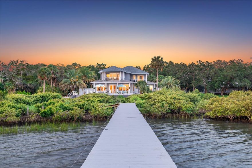 THE PRESERVE at St. Augustine | Nestled on a half-acre waterfront sanctuary encircled by protected wetlands, The Preserve at Saint Augustine offers a once-in-a-lifetime blend of privacy, serenity, and direct Intracoastal access. This bespoke estate is more than a home; it’s an escape into nature’s embrace. Towering palms and ancient oaks line the secluded drive, welcoming you to a residence where the only neighbors are the herons and the coastal breezes. Wake each morning to shimmering water views from expansive windows and gracious outdoor terraces. By day, launch from your private deep water dock for an offshore boating adventure! Glide by paddle board or kayak along the Intracoastal Waterway, exploring winding estuaries alive with coastal wildlife. By evening, savor panoramic sunset vistas over untouched wetlands, with the soft glow of St. Augustine’s historic skyline on the horizon.Designed with effortless coastal elegance, the home’s interiors invite the outside in. Light-filled living spaces open to the gentle breezes off the water, while natural materials and a soothing palette mirror the surrounding landscape. Every room offers a glimpse of the Intracoastal or lush greenery, blurring the lines between indoors and out. Inside, 3,660SF of custom design includes a luminous open layout, a gourmet kitchen with stainless appliances and white shaker cabinetry, and a spa-like primary suite featuring a soaking tub, walk-in shower, dual vanities, sauna, and private balcony. Thoughtful features like a wet bar, a dedicated office, 3 addl. primary suites with their own sitting rooms and private terraces, and a conditioned 750-square-foot garage. Though luxuriously private and tranquil, just minutes from the fine dining, culture, and rich history of America’s oldest city. Here, you can truly have it all: the enchantment of an untouched paradise with the conveniences of modern living close at hand. This rare and coveted location offers direct street access to the white sands of St. Augustine Beach. THE PRESERVE at Saint Augustine is a testament to the idea that luxury is not only defined by opulent amenities, but by space, peace, and the freedom to live completely on your own terms. This exclusive waterfront haven awaits the discerning buyer who dares to dream beyond the ordinary. Don’t miss the opportunity to claim your piece of Florida’s hidden paradise – a sanctuary of natural beauty and seclusion that simply cannot be replicated. With no HOA and short-term rentals allowed, this estate offers both timeless appeal and modern opportunity. Come experience the rare magic of THE PRESERVE at St. Augustine—a private retreat where every moment feels like a timeless escape.