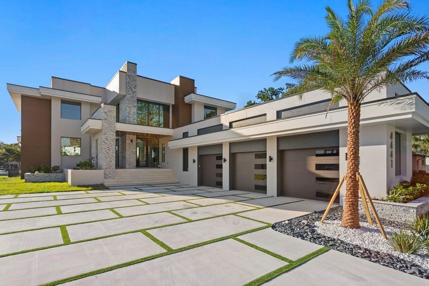 Step inside a home that feels less like a single family residence and more like a modern work of art on the water. This four bedroom, five bathroom masterpiece by Everstone Development rises from the shoreline of St. Petersburg as a statement of refined taste and bold design. From the moment you enter, walls of glass flood the interiors with light, framing the waterfront as if it were a living canvas. Volumes of soaring ceilings, sculptural staircases, and decadent details create a sense of drama, while every finish, each thoughtfully selected, whispers sophistication.
Life here unfolds seamlessly: mornings begin with coffee in the sun splashed kitchen, evenings flow into cocktail hours by the wine bar, and weekends bring friends together in the private media lounge or around the pool as the water glimmers in the background. Even the garage becomes part of the story, with options to create a climate controlled showcase for a collector’s fleet, complete with the option to install lifts for those who treat cars as art.
Beyond the gates of this residence, the city’s energy hums just ten minutes away. Downtown St. Pete offers a world of Michelin level dining, galleries, and boutiques, while white sand beaches and international airports remain effortlessly close. This isn’t simply convenience, it’s connection to the best the Gulf Coast has to offer.
Just blocks away, the neighborhood pulses with new investment and vision. The future is being built here, and this home stands at its center, an anchor of luxury in a district on the rise. To own this property is to claim more than a home; it’s to embrace a lifestyle that marries modern architecture, cosmopolitan ease, and the timeless allure of waterfront living.