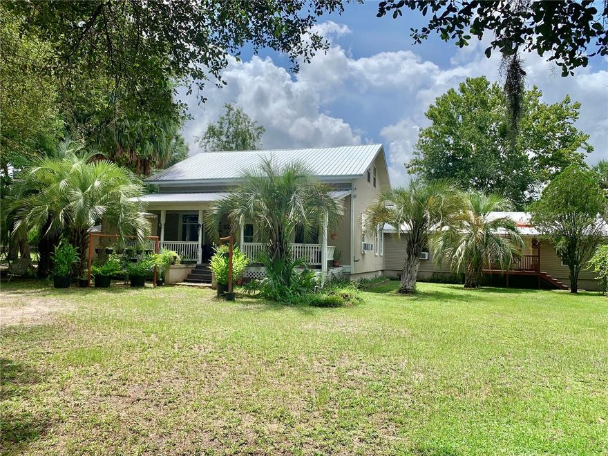 This 1915 Farmhouse gives you a taste of old Florida charm. The large front porch welcomes you with a porch swing and the original front wood-framed windows. Upon entering your eyes are immediately drawn to the high ceilings complimented with two layers of crown molding. The original wood floors stretch from the foyer through the living room, dinning room stair foyer and front bedroom. The kitchen has been updated with beautiful tall wood cabinets complimented with stainless steel appliances. The kitchen also has a breakfast area that can fit a full dinning table if desired. Beyond the stair foyer is and additional bathroom with vintage clawfoot tub to serve the common areas of the home. The primary suite has a sitting room that could be used as an office. Barn doors separate the primary suite and the bonus sitting room. The primary bathroom is spacious and has a jetted soaker tub adorn with updated tile. The walk in closet is surprising with an additional closet within the closet. The primary suite has a private access door that lets out to the back porch/deck area. On the other side of the home you have an additional guest/In-law suite. The guest suite has a foyer are with built in counter that can be used as a kitchenette. There is a nice updated bathroom which services the 2 large guest rooms. This wing of the home also has a separate entrance and front porch deck area making it ideal as an in-law suite. The home has been used previously as a short-term rental income property and can be segmented into 3 spaces with the kitchen and laundry being shared spaces. Upstairs you will find a huge bonus room which could be divided into three spaces to have two more bedrooms with a sitting area in between. Outside you will find a large attached 2 car carport with additional shop area. The back patio leads to the above ground pool, cabana/pergola area with producing muscadine grape vines growing around it. Additionally behind the home you will find a goat shed and chicken coupe. Water spigots have been added all around the yard for easy access for watering the fruit trees and tending the animals. This beautiful mini farm spans 5 acres of fenced land. The property is segmented into different paddocks to house different livestock. The previous owners had chickens, goats, a donkey and a few cows. This home is conveniently located 15 to Gainesville via Williston Rd or Archer Rd. This home has so much to offer as it's well set up for multi-generational family, short term rentals, or a mini farm with lots of space. New well system in 2019, New metal roof in 2018 HVAC older but regularly serviced. Come see what potential this home and property hold for you!