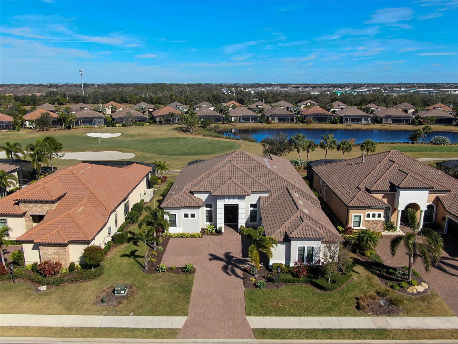 PRICE IMPROVEMENT – NOW $1,799,999! Sellers are also offering a $7400 credit at closing to cover the one-time capital contribution fee!
Where Luxury and Leisure Meet
This isn’t just a home—it’s an invitation to live the life you’ve always dreamed of. Perfectly positioned on the 8th green of the highly sought-after community, Esplanade Golf & Country Club at Lakewood Ranch, this meticulously maintained residence blends luxury, leisure, and effortless elegance. This stunning Mercedes Model home offers breathtaking golf course and water views, impeccable design, and world-class amenities. Featuring 3 bedrooms, each with private baths, plus a half bath, a dedicated office with French doors, and a spacious bonus media room wired for surround sound. Elegant details include soaring 12-foot tray ceilings, crown molding, and luxury laminate wood floors throughout.
The gourmet chef’s kitchen boasts an oversized island, quartz countertops, a 5-burner gas cooktop, double convection ovens, a walk-in pantry, upgraded cabinetry, and under-cabinet lighting. The master suite is a private retreat with custom-built closets, a spa-like bath featuring large-format porcelain tiles, a soaking tub, a walk-in shower, and direct lanai access. Step outside to the screened lanai with a custom heated pool, spa, and a fully equipped outdoor kitchen, perfect for entertaining while enjoying panoramic views of the 8th fairway and green.
This home is equipped with modern technology, including Cat 5 LAN wiring, Cat 6 outlets, and high-speed internet throughout. The 3-car garage provides additional overhead storage, workshop space, and a water line for a garage refrigerator. HOA fees include bundled golf membership, maintenance-free living, and access to resort-style amenities such as two pools, tennis and pickleball courts, fitness centers, a full-service spa, and on-site dining at The Barrel House Bistro and Bahama Bar and more!
Located just minutes from Lakewood Ranch Main Street, University Town Center, and Florida’s top-rated beaches, this home offers an unmatched lifestyle in one of the region’s most desirable communities. With its recent price improvement, this is a rare opportunity to own a luxury golf course home at an incredible value. Schedule your private showing today!
