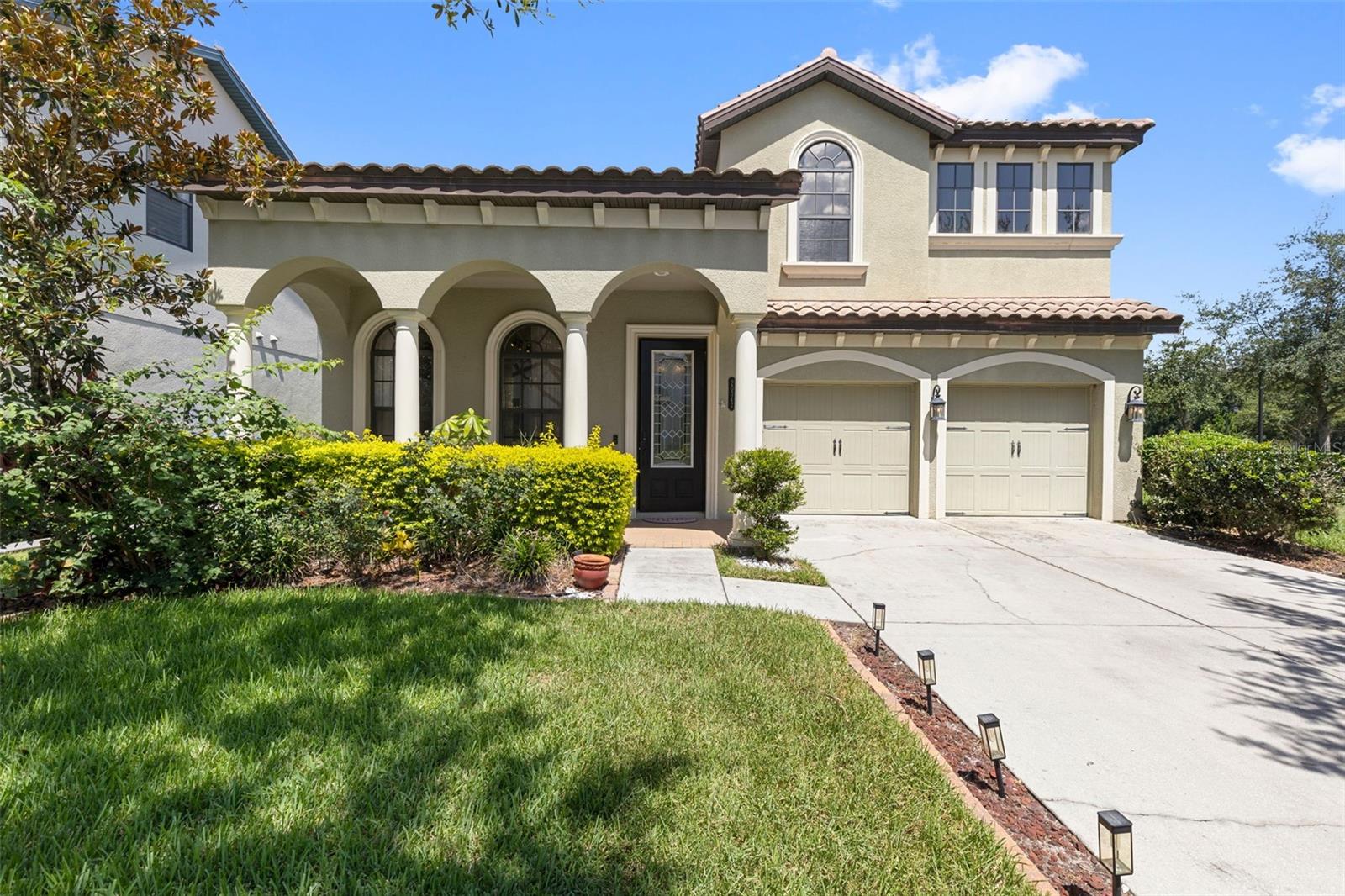 One or more photo(s) has been virtually staged. Poised on a serene corner lot in the sought-after Grand Hampton community, this stunning 4-bedroom + bonus room, 2.5-bath, 2-car garage residence offers a blend of architectural charm, thoughtful design, and breathtaking pond and conservation views. Meticulously maintained landscaping and elegant outdoor lighting set the stage as you approach the home, with a distinctive barrel tile roof adding timeless character. A covered front porch and glass wood-framed door invite you inside, where abundant natural sunlight illuminates each thoughtfully designed space. Just off the entryway, a versatile front living area with a custom wood feature wall provides the ideal setting for a pool table or creative workspace. Continue into the formal dining room, centered beneath a stylish modern light fixture—perfect for hosting intimate dinners or festive gatherings. Nearby, a dry bar framed by a graceful architectural arch features wine refrigerator, quartz countertops, a wine rack, and cabinet—both functional and striking. The heart of the home is the expansive secondary living room, with recessed lighting, large windows framing the tranquil water and conservation views, and an effortless flow into the gourmet kitchen. Designed to impress, this chef’s haven includes white soft-close cabinetry, quartz countertops, tile backsplash, upgraded lighting fixtures, stainless steel appliances—with stove and microwave controllable via the Whirlpool app—and a gas cooktop. A stunning waterfall-edge island serves as both a focal point and a functional centerpiece for casual dining and entertaining. Every meal comes with a view, courtesy of the kitchen window. A pantry with a stylish glass wood-framed door enhances both convenience and design. Tucked behind the kitchen, a powder room boasts a vessel sink with quartz countertop vanity. Nearby, a private bonus room offers flexibility for an office or guest space. Ascend the oak staircase with wide risers to discover soaring 9-foot ceilings and sun-filled spaces throughout the second floor. The split-bedroom layout offers privacy and comfort, starting with the luxurious primary suite. A graceful arched entry leads to a spacious sitting area with cascading windows, updated light fixture, and tranquil views of the pond. The ensuite bath is a true retreat, featuring a dual vessel sink quartz vanity, freestanding soaking tub, frameless glass walk-in shower, and an expansive walk-in closet tucked behind a modern barn door. Also upstairs are three generously sized bedrooms, a full bathroom with quartz countertops, dual vessel sinks, and a smart Jack-and-Jill layout connected via pocket doors. The laundry room featuring updated porcelain tile (2024), conveniently located on the second floor, completes the upper level. Step outside to your Florida oasis—a screened lanai offering peaceful water and wooded views, perfect for morning coffee or evening relaxation. Just off to the side, a cozy patio seating area awaits, ideal for a fire pit and enjoying starlit nights. Notable features include: Water Heater (2022), Dual HVAC systems (2022), 5¼" Baseboards, 8' Doors throughout, Irrigation System, Thermostat is Honeywell Pro Series managed by Resideo App, and Washer is App-controlled by Samsung SmartThings. This home is located within the highly sought-after, resort-style community. Grand Hampton offers amenities such as: A clubhouse, fitness center, lap and lagoon pool, tennis courts, playgrounds, and walking trails. Don't Miss Out!