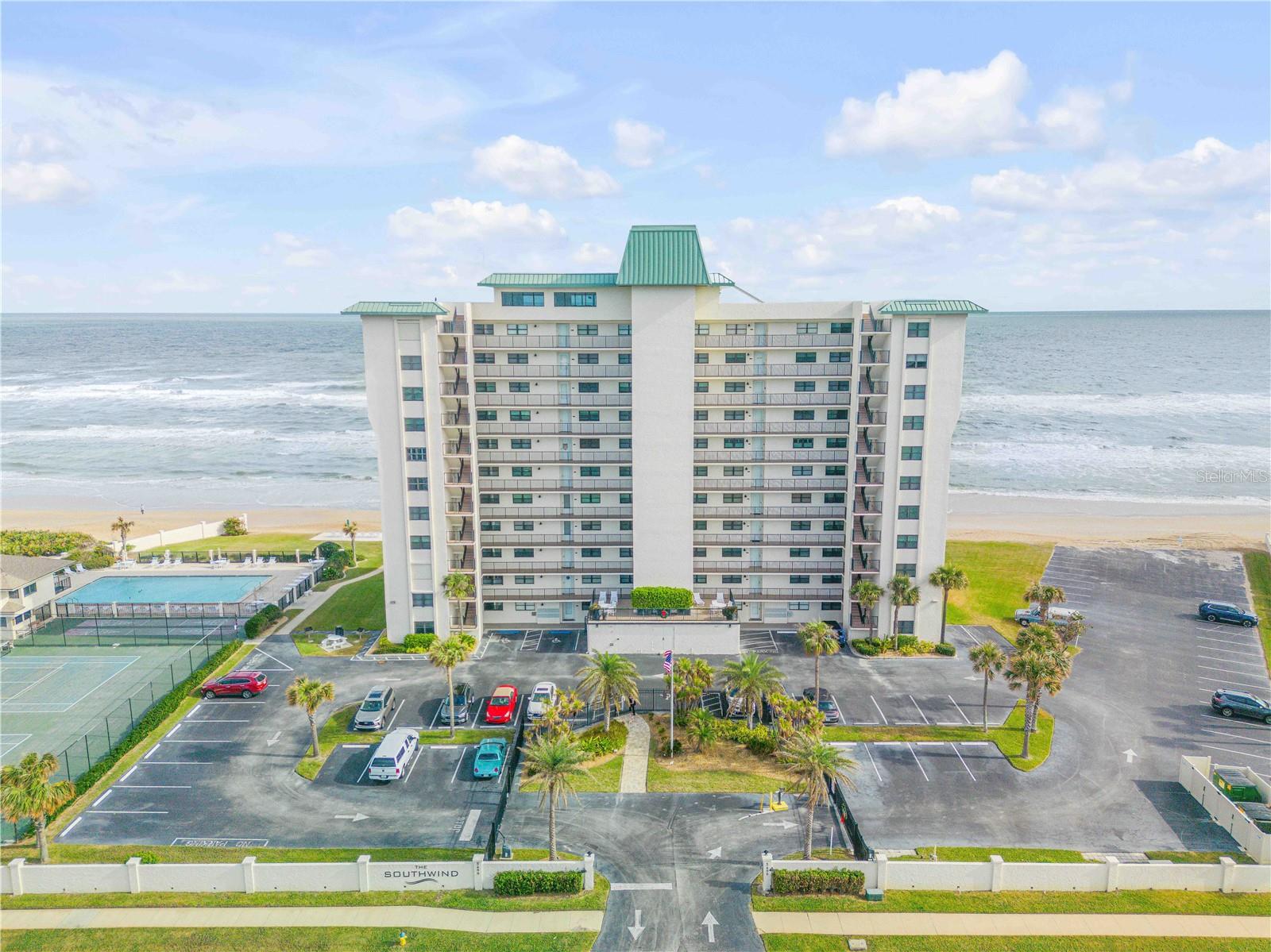 Perched on what many consider the ideal level for oceanfront living, this second-floor unit offers a rare, immersive beach experience; close enough to hear the waves and see the sand, yet high enough for privacy and sweeping views. With a 12-foot sliding glass door framing the Atlantic like a living work of art, the line between indoor and shoreline living nearly disappears. Whether you're enjoying sunrise coffee or evening cocktails, the sound of the waves is your daily soundtrack. This condo is also a high-income producing short-term rental, making it an excellent opportunity for both lifestyle buyers and savvy investors. Inside, plantation shutters add coastal charm and privacy, while both bathrooms have been completely renovated with a sleek, modern design. An oversized utility closet provides rare extra storage, and upgrades like hurricane shutters, a 2024 water heater, and a high-efficiency 2023 Carrier HVAC system bring peace of mind and long-term value. The building features a central chiller system, meaning there are no bulky or noisy A/C units on the roof resulting in better energy efficiency, quieter operation, and a cleaner exterior profile for the entire complex. Located on the no-drive section of New Smyrna Beach, you'll enjoy a peaceful, pedestrian-friendly shoreline. Amenities include a beachfront pool, a 12th-floor clubhouse with panoramic views, and coming this September, fully rebuilt sport courts featuring two brand new pickleball courts and a tennis court. Just minutes from Canaveral National Seashore, BJs Restaurant, and only 10 minutes to Flagler Ave, this condo is more than just a home, it’s a front-row seat to the Atlantic.