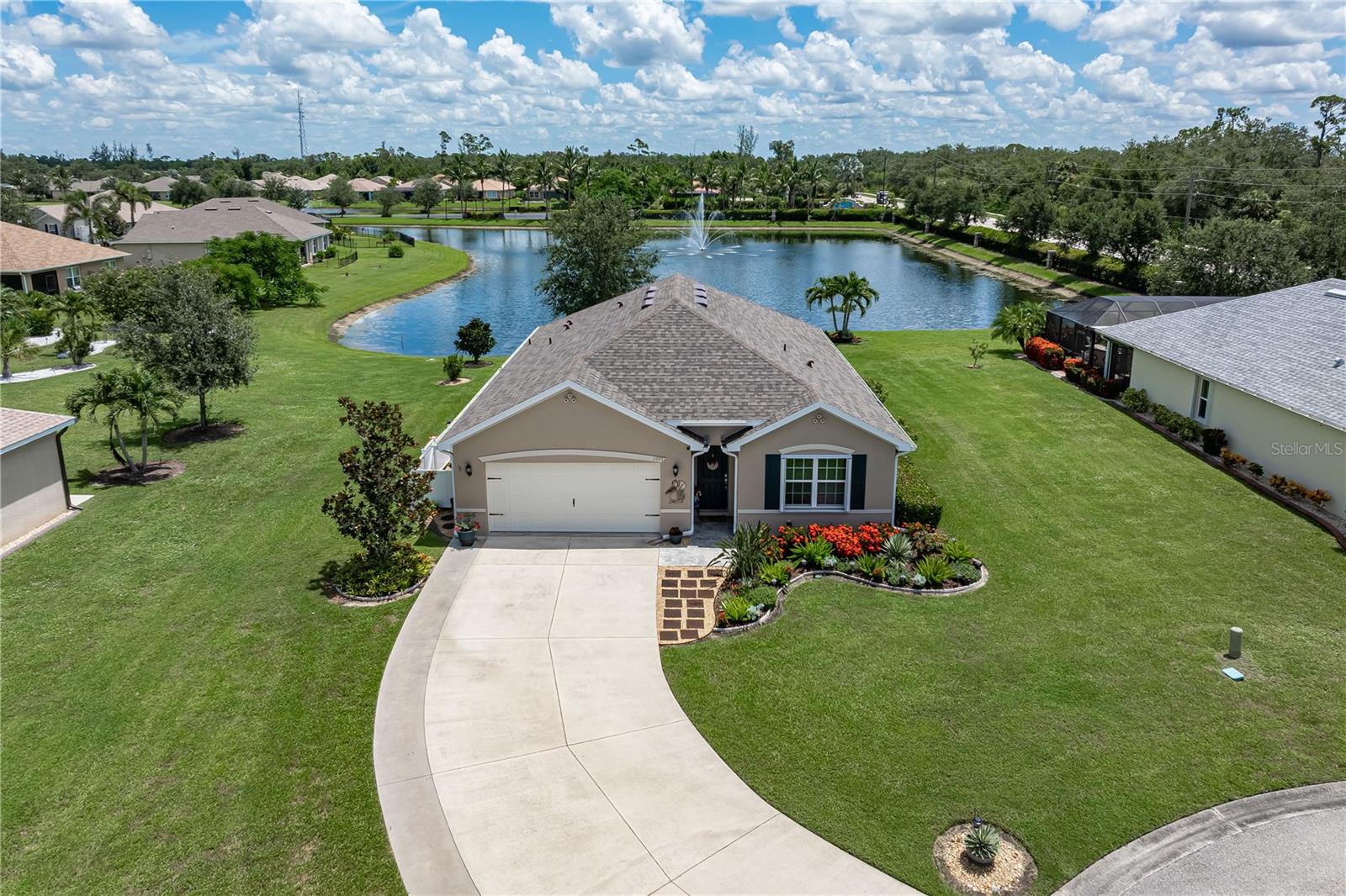 LAKEFRONT HOME ON OVERSIZED LOT IN WATERFORD ESTATES This **FOUR** bed/TWO bath home, located in the gated community of Waterford Estates, commands one of the neighborhood’s most desirable oversized lots with an extra-wide footprint and an unforgettable lake view. From your lanai, watch the water shimmer with a central fountain framed by lush landscaping and wide open skies. The community offers two pools, a clubhouse with fitness, billiards, and cards, plus pickleball and bocce courts — all just minutes from historic downtown Punta Gorda, Fishermen’s Village, US41, I-75, and PGD airport. Lawn care, trimming, irrigation, and recreation facilities are covered by low quarterly HOA fees. Inside, the open-concept layout is anchored by a coastal-inspired chef’s kitchen featuring brand-new counters, a striking center island with pendant lighting, rustic paneling detail, a breakfast bar, and a walk-in corner pantry. The kitchen flows into the spacious dining area and great room, where UV-protected windows and sliding glass doors bring in the lake view and natural light. Warm-toned luxury vinyl plank flooring runs throughout the main living areas, creating a seamless sense of space and style. The master retreat offers an en-suite, private bath with dual sinks, a large linen closet, and a tiled shower with adjustable shower head plus an oversized walk-in closet. Three guest bedrooms share a bright guest bath with combination tub/shower. Outdoor living takes center stage with an L-shaped, picture-frame-screened lanai finished in stamped concrete, creating a breezy extension of the home’s living space. The backyard unfolds to a manicured lawn that meets the water’s edge, providing unobstructed views and a serene setting for morning coffee. With a widened driveway, whole-house hurricane protection, gas generator hookup, new roof (2022), and fresh exterior paint (2024), this lakefront beauty is truly move-in ready. Low-voltage lighting brightens up the home at night for a beautiful look. A privacy fence at the side of the home covers trash bins while providing additional storage for bikes or other items. Waterford Estates is a growing community w/two gated entrances, two pools, a community center w/catering kitchen, billiards & card rooms plus a fitness center, four pickleball & three bocce courts. Miles of sidewalks in Waterford's park-like setting provide a scenic backdrop to your evening stroll. Enjoy the tranquility of passing by lakes and manicured, tropical landscaping. Schedule your appointment today and experience the Waterford Estates lifestyle for yourself. Home has a transferrable flood policy w/$930 premium ($4,454 discount).