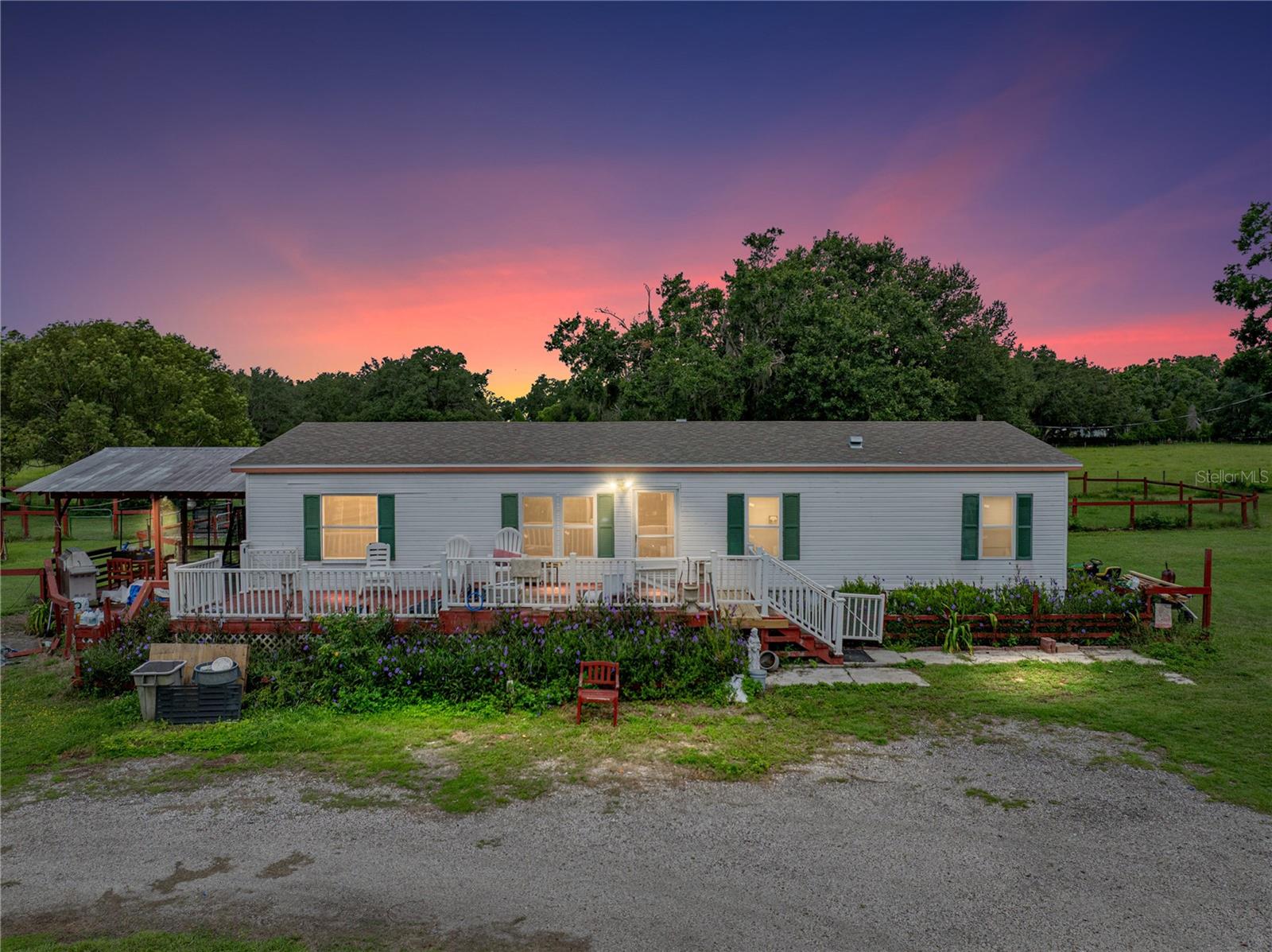 Bring your animals and your vision to this scenic 5.52-acre property nestled along a private road
in one of Dade City's most picturesque settings! Designed with agricultural living in mind, the
land is fully outfitted with several cross-fenced pastures, covered stalls, and multiple animal
pens, ideal for anyone with horses, livestock, or a passion for country life. A long, tree-lined
driveway leads to a circular courtyard where the main residence is situated, surrounded by wide
open space and natural beauty. Further back on the property, you'll find a private 1 bedroom, 1
bath in-law suite resting in its own fenced section, offering privacy and flexibility for
multigenerational living or guest accommodations. The main home is a 3 bedroom, 2 bath
manufactured residence with multiple outdoor areas to sit and enjoy the private land, including a
front deck with peaceful views, a shaded side deck, and an above-ground pool. Inside, an open
concept layout with vaulted ceilings and durable vinyl plank flooring creates a spacious and
functional main living area. The kitchen is centrally located between the formal living/dining
room and the family room, and features stainless steel appliances, breakfast bar seating, a
decorative backsplash, and sliding doors that lead to a temperature-controlled enclosed porch,
perfect for relaxed mornings or quiet evenings. The primary suite is set apart for privacy and
offers a rustic accent wall, a walk-in closet, and an ensuite bathroom with dual sinks and a walk-
in shower. Bedrooms 2 and 3 are on the opposite side of the home and share a full bathroom in
between. The detached in-law suite spans over 450 square feet and includes its own living area,
kitchenette, vinyl plank flooring, and a full bathroom - all privately placed at the back of the
property in its own enclosed section. Whether you need separate space for family, want to create
a home office or studio, or just need room to grow, this setup offers endless possibilities. With
usable land, existing infrastructure for animals, and a quiet rural setting just minutes from town,
this property is ideal for those looking to live a laid-back lifestyle with space to spread out. Call
today to schedule your private tour.