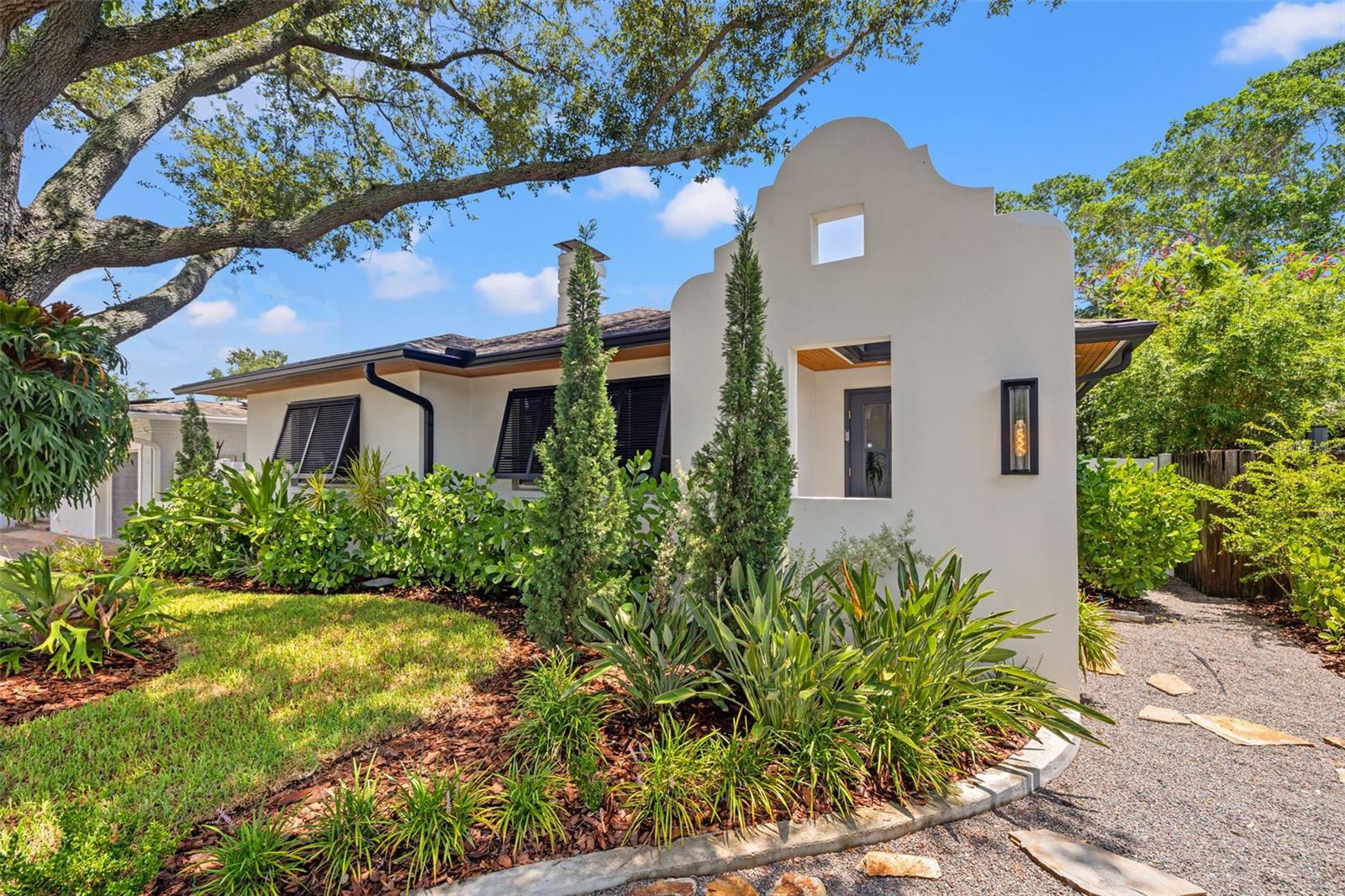 Where luxury meets lifestyle in the heart of Granada Terrace.
Step into a one-of-a-kind showpiece just steps from Coffee Pot Bayou and a short stroll to downtown St. Pete. Completely reimagined with a designer’s touch, this home blends sophisticated Dutch West Indies architecture with modern upgrades inside and out.
The exterior stuns with artisan-crafted Bahama shutters, architectural entryway, and a cozy backyard fireplace — all surrounded by lush new landscaping, sod, and lighting that makes the whole home glow at night. Inside, every inch has been elevated: herringbone luxury vinyl floors, custom trim and wainscoting, and statement lighting that belongs in a design magazine. The kitchen is pure culinary theater with custom white oak cabinets, brass details, high-end Fisher & Paykel appliances, and an LG Smart refrigerator with craft ice.
The living room features a raked plaster fireplace and custom walnut dry bar — perfect for entertaining. The spa-worthy bath wows with a tiled arch shower entry and brass accents, while custom closets keep everything beautifully organized.
This isn’t just a home — it’s a statement. A short walk to waterfront paths, vibrant downtown dining, and everything that makes St. Pete living iconic.