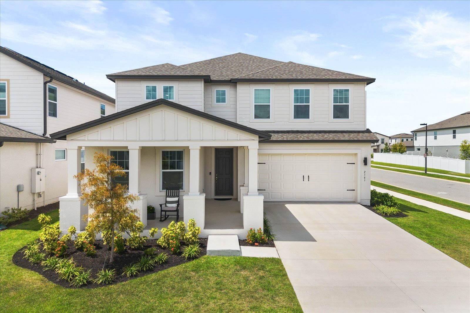 Welcome to 2161 Gold Dust Drive in the Hills of Minneola, a beautifully designed home offering nearly 4,000 sq. ft. of living space. This six-bedroom, five-and-a-half-bath residence sits on a desirable corner lot and combines elegant finishes with modern conveniences.
The first floor features an open layout with a spacious living area, dining room, and a chef’s kitchen that will impress any home cook. The kitchen is equipped with an oversized 11-foot island, apron-front sink, double-stacked cabinetry, pot filler, butler’s pantry, walk-in pantry, and high-end Samsung smart appliances. Designer details such as quartz countertops, custom tile work in baths and showers, oak ceiling beams, and Pottery Barn fixtures elevate every space. Upstairs, the primary suite is a true retreat with a tray ceiling, freestanding soaking tub, oversized shower, dual vanities, and a large walk-in closet. Additional bedrooms are generously sized, and two of the rooms even feature closets large enough to be used as a home office or gaming space. Designer details throughout include oak ceiling beams, custom tile baths, and stylish finishes. Practical features include a 3-car garage with smart opener and overhead storage, a covered lanai, full sprinkler system, and builder’s full home warranty. The Hills of Minneola will feature resort-style amenities: two pools, clubhouse, fitness center, pickleball courts, parks, and dog parks. The planned Pointe Town Center development will feature restaurants, entertainment, splash pads, and an amphitheater, all located nearby. Conveniently located near the Florida Turnpike, Winter Garden, theme parks, downtown Orlando, and Orlando International Airport, this property combines comfort, luxury, and accessibility in one exceptional package.