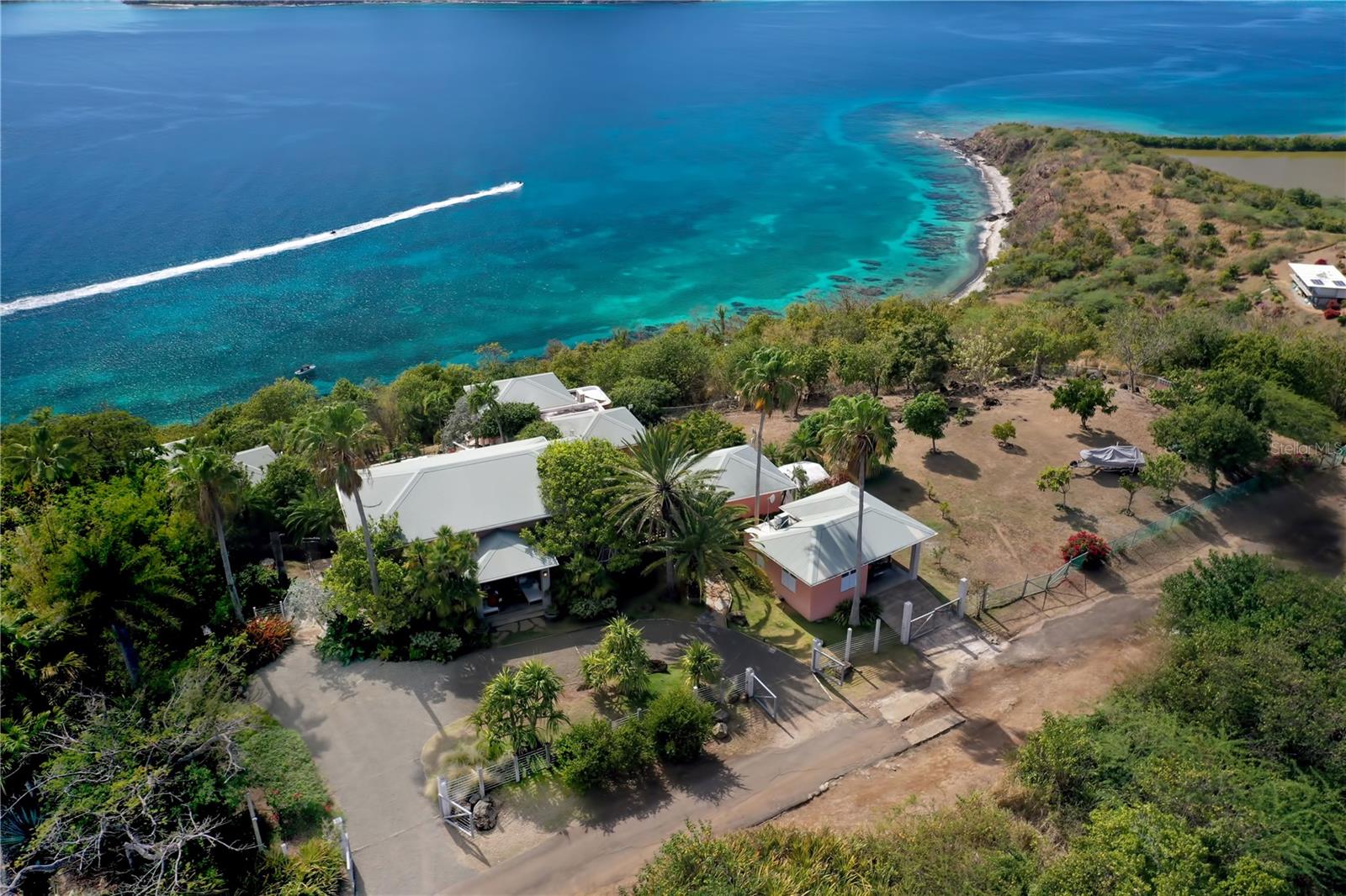 Perched atop a hill overlooking the Caribbean Sea in enchanting Culebra Island, this five-bedroom beautifully landscaped compound of nearly 2 acres, offers picturesque views of a stunning seascape, dotted with neighboring keys.
Consisting of five cottages spanning approximately 3,221 square feet, this private residence emanates comfort and ease in a peaceful and tranquil environment. The heart of the home is the primary bungalow. It encompasses an elegant spacious great room with voluminous wood-beamed cathedral ceiling that reinforces the warm atmosphere, fully equipped kitchen, and light-filled living and dining room that flow to an exterior terrace overlooking the pool, sundeck, and to the expansive outdoor living areas showcasing panoramic views of Cayo Luis Peña.
Designed by renowned architect Pedro Rodriguez Flores, the four adjacent casitas are accessed by stone staircases and pathways and include independent entrances that allow privacy. The interiors feature high quality materials and finishes throughout, en-suite bathrooms and balconies with spectacular ocean vistas. This private retreat offers generous accommodations for a large family, visiting friends, or can also be used as a vacation rental.
The great outdoors featuring open terraces and verdant patios embraced by nature’s vibrant hues, is great for entertainment, barbecuing and alfresco dining. It offers the perfect setting to enjoy glorious sunrises and breathtaking Caribbean sunsets. Other amenities in this enclave include custom built-in grill, exterior lighting system, outdoor guest bath, full back up electric generator, water cistern, garage, laundry room, pantry, multiple storage closets.
This unique tropical estate surrounded by lush vegetation, sits in a 7,948 square meter double lot, providing privacy and tranquility, yet one of its finest features is its proximity to various pristine beaches where you can enjoy a wide range of aquatic sports and recreational activities, and the convenience of a 10-minutes’ drive to town, making it the perfect choice in Culebra.
Culebra Island is located off the eastern coast of the mainland of Puerto Rico; it is accessed by boat, ferry and numerous daily flights from San Juan and Ceiba.