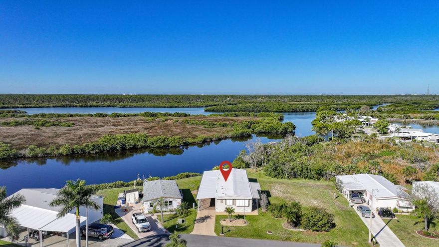 WATERFRONT LIVING AT ITS FINEST! This unique TURNKEY FURNISHED home is ideally situated at the end of a quiet cul-de-sac on the Myakka River. Extensive upgrades have been completed: Roof, Carport, Shed 2023, HVAC 2020, new water lines, subflooring, tie-downs, ductwork, an updated electrical panel, Bahama Shutters on all windows, metal roll-down shutters on Florida room windows, and an accordion shutter on lanai sliding door. Public water/sewer. This home features vaulted ceilings with real wood beams in the living, dining, and breakfast areas, creating a warm and inviting coastal feel. The kitchen has been completely remodeled in 2020 with high-quality white shaker cabinetry, including a spacious 36" pantry with 4 pull-out shelving, a cabinet for storing larger countertop appliances, a double trash drawer, and ample storage throughout. Granite countertops extend to a large (approx) 4' x 8' peninsula with seating for four and additional storage. Additional highlights include a deep double stainless sink with instant hot water, stainless steel appliances, and recessed lighting that create a bright, inviting space. The dining room features a dry bar with matching kitchen cabinetry and granite countertops. A painted shiplap accent wall in the breakfast room adds a pop of color with dual closets providing additional storage. Primary bedroom remodeled in 2023; features new insulation, ceiling, waterproof vinyl plank flooring, fresh paint, ceiling fan, and two walls of windows for natural light. Remodeled spa-like primary bath with a custom tiled walk-in shower with bench and niche, dual granite vanity that complements the tile flooring, and an extra-large walk-in closet. The guest bedroom features an updated ceiling, a new fan, and fresh paint. The guest bath was updated in 2020 with a marble-top vanity and waterproof vinyl flooring. Designed for gatherings, this home offers multiple seating areas for relaxing or entertaining, with space for dining, game nights, or watching the big game. The enclosed lanai with Tiki bar provides the perfect setup for outdoor entertaining and barbecues. A long, extended driveway, professionally sealed and coated, offers ample parking. Exceptional privacy with lush natural vegetation and no rear neighbors across the canal. Enjoy peaceful waterfront views of the river, where dolphins, manatees, and a variety of birds are frequent visitors, along with stunning Southwest Florida sunset skies each evening. The Myakka River flows into Charlotte Harbor, which opens to the Gulf of Mexico. Approximately a 1-hour boat ride from Harbor Cove to the Gulf, depending on speed and conditions. Experience the best of Florida’s retirement lifestyle; Harbor Cove, a sought-after 55+ waterfront community along the scenic Myakka River, filled with resort-style amenities. NO LOT rent. Monthly HOA fee is $175 per month; includes lawn care and access to Resort-style amenities with two sparkling heated pools, a relaxing spa, a well-equipped fitness center, a clubhouse overlooking the stunning 90-slip Marina, shuffleboard, horseshoes, pickleball, tennis, and bocce courts. Socialize and stay active with dances, parties, water aerobics, fitness classes, art classes, woodworking, golf cart parades, bingo, dances, and more. Boat clubs, a craft room, picnics on the patio, golf clubs, and much more. Conveniently located within minutes of Downtown Wellen Park and a short drive to beautiful Gulf Beaches.