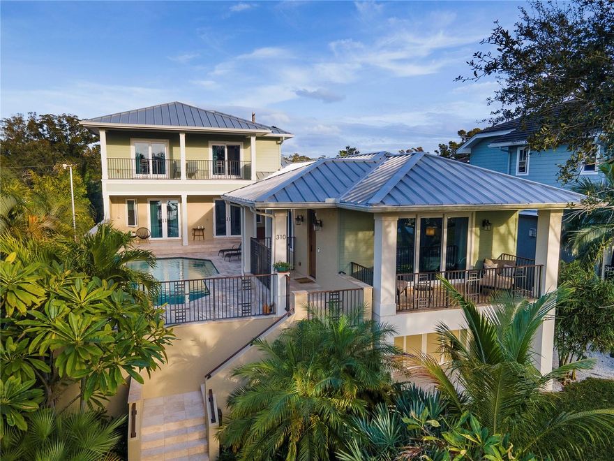 Experience the pinnacle of waterfront luxury in this exquisite COASTAL CUSTOM HOME, built in 2015 with sustainability in mind and the latest state-of-the-art amenities.  Every room in this modern architectural masterpiece offers breathtaking water views, creating a seamless connection with the coastal landscape.  The home features a stunning open-concept floor plan meticulously designed to maximize space for entertainment.  Revel in the elegance of the main living space consisting of a living room graced with soaring vaulted ceilings, dining area adorned with a 10’ beamed ceiling, and a stunning designer kitchen. Impressive 8’ PGT French doors open to an awe-inspiring outdoor oasis.  This elevated travertine courtyard is complete with a saltwater pool that is solar heated, has a waterfall feature, LED lighting and a quartz pool finish.  This space offers a seamless flow from the interior to entertaining alfresco!  The gourmet kitchen is a chef's dream, showcasing custom full-height cabinets and shelves, sleek granite countertops and bar, stainless steel appliances, and a cleverly concealed pantry. A natural gas stove and water heater increase the home's efficiency and convenience. The grand executive office/den makes working from home a delight.  Glass doors lead to courtyard pool and allow a serene view of the bay. The opulent primary suite on the main level is a sanctuary of luxury, offering captivating waterfront views, a spacious walk-in closet, an additional wall closet, and a lavish bathroom. The top floor houses additional bedrooms with oak hardwood flooring, full bath and balconies overlooking the waterfront. The exclusive waterfront parcel across the street includes grounds and private dock.  This dock includes a 10,000 lb boat lift, complete with 16’ dual bunks, caters to small vessels and jet skis, while water and electric services at the dock ensure complete boating convenience. For car enthusiasts, the ground floor features a grand 2,393 sq ft garage with a fully epoxy-coated floor capable of accommodating 8+ cars. Two garage doors provide access from the alley and one convenient garage door from the front of the home.  Constructed with uncompromising quality, the three-story residence features complete concrete construction on the first two floors and wood construction on the third, all built to the latest hurricane codes. The home's exterior blends durability and style, featuring stucco and Hardie board siding.  A 50-year standing seam metal roof adds to the home's resilience. Energy efficiency is at the forefront, with an 8.7 KW solar electric system (owned), reducing the total electric cost to approximately $400 per YEAR! The home is wired for a 10KW generator (a temporary emergency generator is included).  Privacy and security are paramount, with concrete block fencing walls surrounding the property. The mature landscaping, complete with an irrigation system, adds to the home's curb appeal and tranquility. This exquisite waterfront property is a harmonious blend of luxury, modernity, and sustainability, offering an unparalleled lifestyle in one of the most desirable locations in Florida.