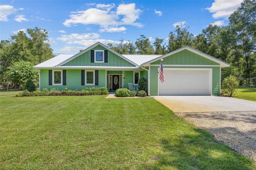 Within the peaceful community of Chesborough’s Corner in High Springs, this thoughtfully crafted home on 5 acres embodies quality, intention, and timeless appeal. Beyond the gracefully curved, tree-lined drive, this custom-built 2021 modern farmhouse is anchored by a pristine lawn that gives way to a backdrop of towering pines and oaks. Before heading inside, you will want to pause on the welcoming front porch, a perfect spot for morning coffee while taking in the quiet beauty of the natural surroundings. As you step through the front door, you are greeted by an expansive open-concept layout defined by high ceilings and luxury vinyl plank flooring that radiates natural light across the heart of the home. Overlooking the spacious living and dining areas is the chef-inspired gourmet kitchen, a perfect hub for entertaining with sleek quartz countertops, stainless steel appliances, a pantry with ample shelving, and a large central island. From casual gatherings to large celebrations, the living space’s intuitive design keeps everyone connected without interrupting the conversation. Glass doors off the dining area open to a lovely sunroom featuring a convenient half-bath and entry to the 2-car garage. Tucked away for maximum privacy, the primary suite serves as a true retreat and boasts a walk-in closet and ensuite with double vanities, a walk-in shower, and a linen closet. Two guest bedrooms and a full guest bath with a tub and shower combo provide ample space for friends and family members. Step outside to find a beautiful backyard featuring a patio and a detached 24x40 metal barn with a lean-to, roll-up door, electric, and water, making it the perfect workshop and garage for equipment and outdoor toys. With no HOA and 5 acres of versatile land, this property is also a haven for animal lovers, as both horses and chickens are welcome. Beyond the aesthetic, this home is engineered for modern efficiency, featuring energy-saving spray foam insulation in the attic, irrigation around the home, a stem wall foundation, a lifetime warranty on windows, underground utilities, and high-speed Wi-Fi capability. Located in Chesborough’s Corner, you are just minutes from the world-famous freshwater springs and the Santa Fe River, while enjoying a convenient commute to I-75 and the city amenities of Gainesville. Rarely does a property capture the quiet soul of the Florida countryside while offering the luxurious comforts of a custom-built retreat, but this property does exactly that. Schedule a private tour today to experience this High Springs gem for yourself!