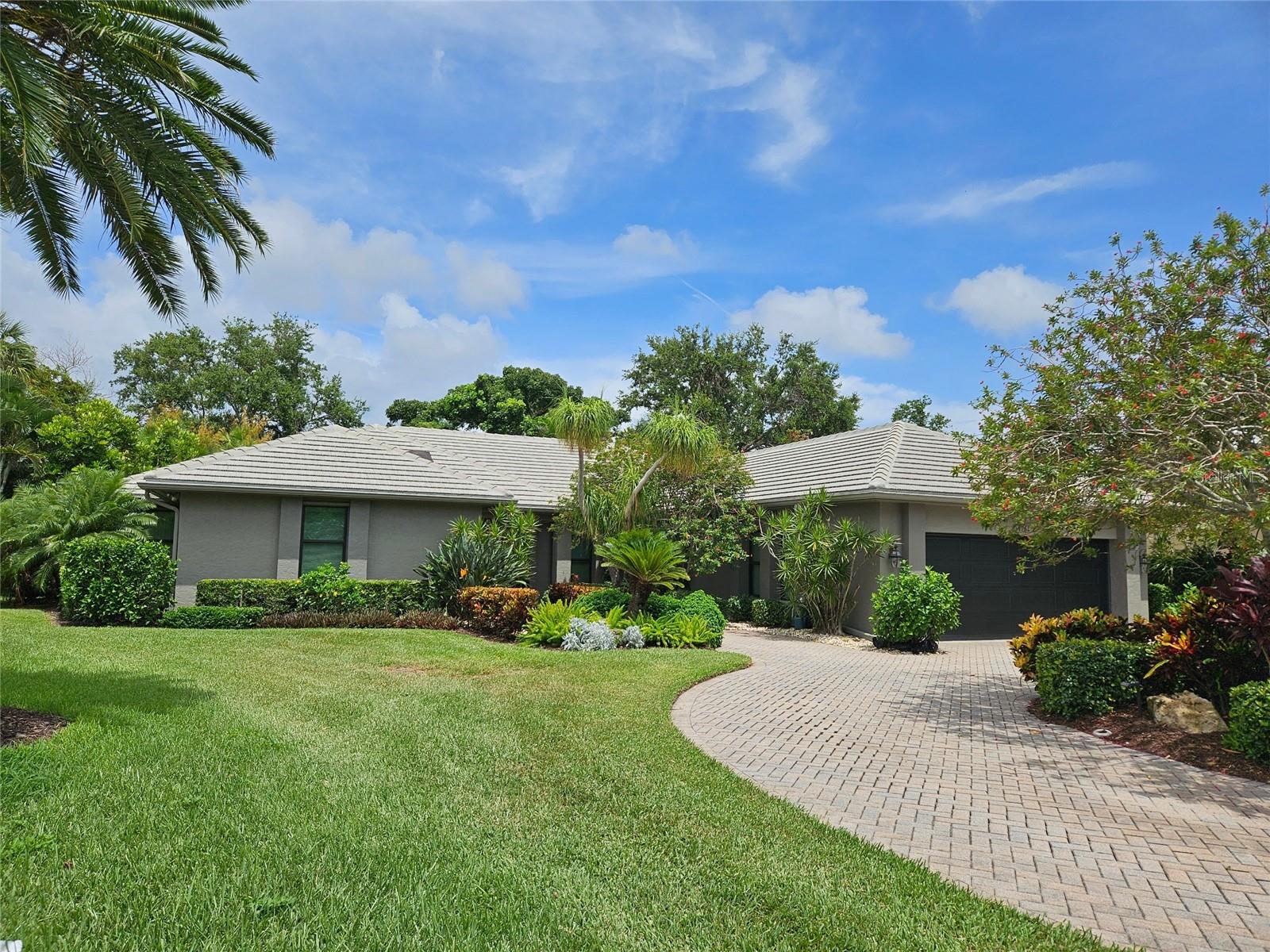Located in Sarasota’s coveted and 24-hour guard-gated West of Trail community, The Landings, this beautifully reimagined 3-bedroom, 3-bath residence with a bonus room offers refined coastal living and peace of mind through extensive, high-quality updates. Situated on a lushly landscaped lot with mature trees and privacy and not in a flood zone, this 2,921 sf home blends timeless architecture with thoughtful modern improvements, all just minutes from Siesta Key’s world-famous beaches and Downtown Sarasota. Hurricane-impact windows were added in 2023, all new hurricane sliders are being installed soon, and the newer roof and updated PVC plumbing offer structural integrity and long-term value. Design upgrades include porcelain tile flooring and beautiful custom wood cabinetry and built-ins. The fully updated kitchen features premium stainless appliances, Silestone counters, stylish cabinetry, a picture frame window overlooking the beautiful garden, a convenient pass thru window to the lanai, and custom walk-in pantry. The adjacent dining room is perfect for entertaining and the formal living room with its high ceiling is anchored by a woodburning fireplace with tiled hearth and built-ins. The split-bedroom floor plan offers privacy and functionality, with all 3 bedrooms, (one currently outfitted as a convenient home office with solid wood built-ins) boasting custom walk-in closets and lovely bathrooms. A spacious bonus room is light and bright and includes a redesigned alcove with floor-to-ceiling custom built-ins to house books, media, or art. Every inch of this home reflects quality, style, and enduring craftsmanship. The interior of the home flows seamlessly to the elegant and serene exterior where you will enjoy the professionally redesigned landscape with exquisite plantings, brick paver driveway, meandering walking path, elevated relaxation area, peaceful fountain, and custom exterior lighting. The spectacular pool area underwent a major renovation in 2020 which included resurfacing with Pebble Tec (lifetime warranty), installation of a new heater and pump, and the addition of a stylish new Italian tile surround. The lanai was rescreened in 2023 and the deck was upgraded with a high-performance Pro Tech surface for durability and beauty. Located behind the gates of The Landings, residents enjoy tree-canopied streets, a nature trail leading to Roberts Bay, and optional membership to the Landings Racquet Club, offering tennis, pickleball, a heated pool, fitness center, and clubhouse. With proximity to A-rated schools, Southside Village, Sarasota Memorial Hospital, and the cultural amenities of downtown Sarasota, this property is a rare opportunity to own a truly move-in-ready home in one of Sarasota’s most sought-after communities.