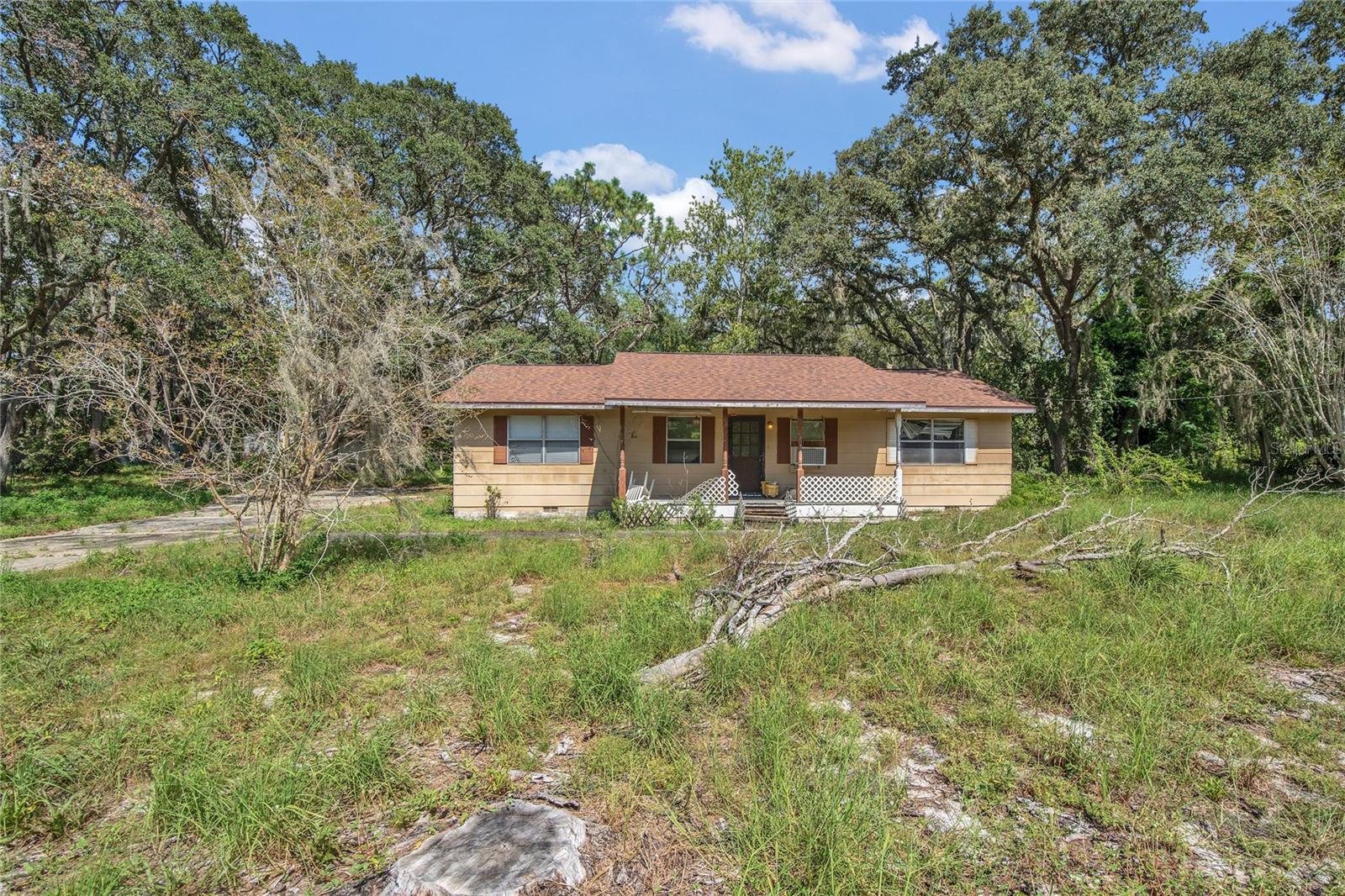 This 3-bedroom, 2-bath original Jim Walter-raised foundation home is the definition of a fixer-upper. Inside, you’ll find plywood floors throughout, awning-style windows that have seen many seasons, and a rough, dated kitchen area ready for a total overhaul. Some flooring areas are soft and rotted, and the three bedrooms—each with small closets—are functional but far from spacious.
Still, the lot itself tells another story. The yard is sprinkled with blooming trees that add beauty and a sense of possibility, creating an inviting backdrop for whatever you envision here. Build your dream home from the ground up, restore the existing structure, or explore potential commercial use—the location offers flexibility.
Neighboring a well-established nursery, the property shares a common easement with three other homes, providing access while keeping a tucked-away feel. For the right buyer with vision (and a toolbox), this could be a rare opportunity to transform a rough property into something truly special.