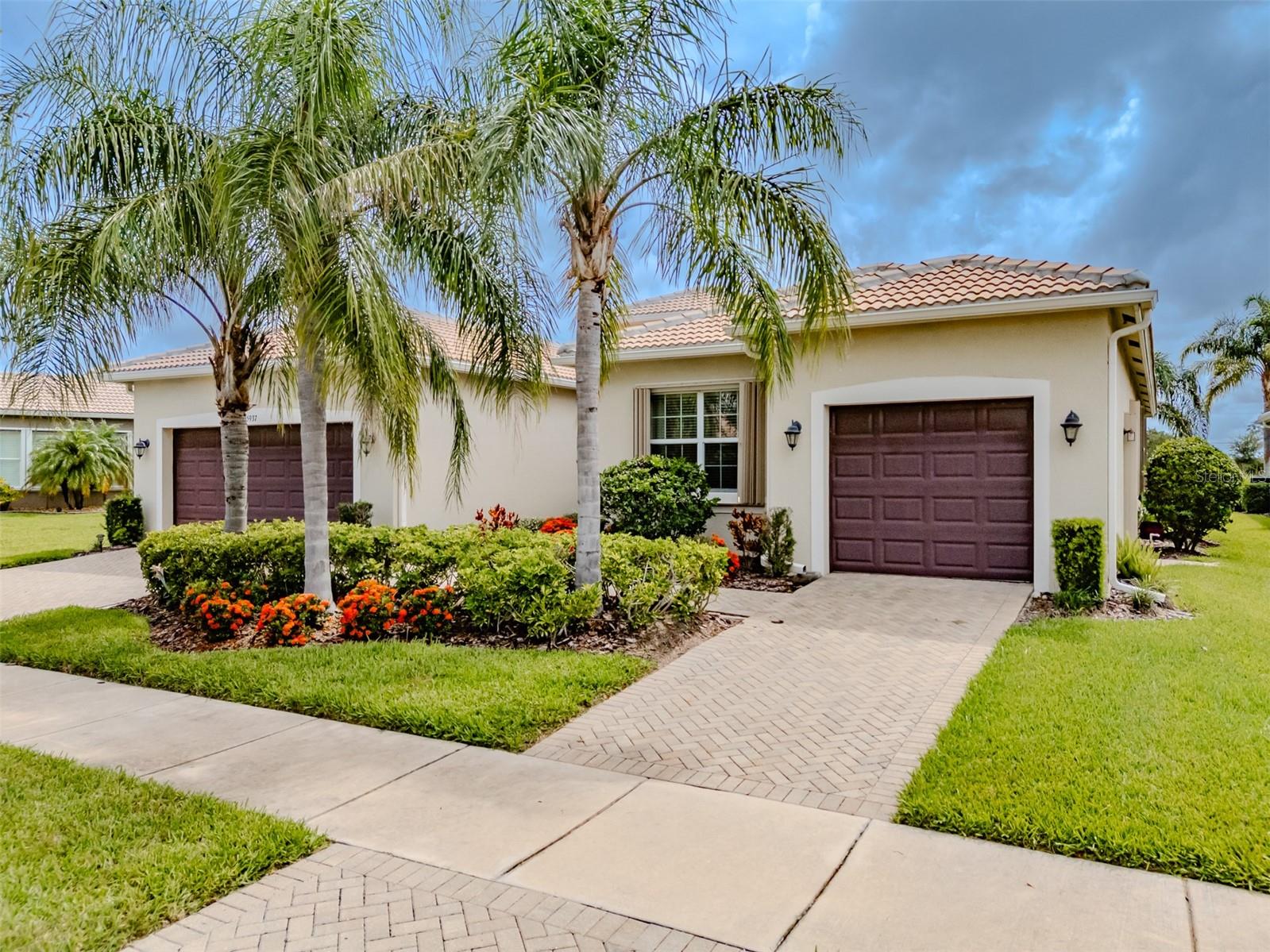 Subtly elegant yet wonderfully comfortable. Seize the day and make this GL Homes built BELLAGIO your private oasis. Located in Valencia Lakes, Tampa Bay's premier 55+ Active Adult Community, this BELLAGIO will be a house that you will be extremely proud to call home. With 2,623SF under air, it features 3 Bedrooms, an Office/Den, an expansive Great Room, Gourmet Kitchen with a Family Dining Area, a separate Dining Room, a two-car Garage, and a single-car Garage, both with 2' extensions. Accordion hurricane shutters adorn the windows, save for the 3-panel Bay windows in the Master bedroom that have been updated with hurricane/impact resistant windows. The double-French full-length glass front doors feature adjustable shades between the glass and provide a secure and warm welcome. The Foyer has a 13’ ceiling and a magnificent view of this exceptional open floorplan that features 18”x18” porcelain tiles capped by 5” baseboards and crown molding will be found throughout the common areas. Immediately forward of the Foyer is a spacious 22’x21’ Great Room with a 10’-to-11’ tray ceiling with a lighted ceiling fan, and 16’ wide sliding glass doors leading to the Lanai with a serene water view. The 240SF Lanai is a wonderful space to enjoy outdoor living with lots of privacy and there is abundant space out back for a pool. A stained-glass chandelier adorns the Dining Room that will comfortably host 10 persons. Spacious, and functional best describes the Gourmet Kitchen which is the crown-jewel of this home. 42” solid wood cabinetry abounds, and it is topped with sublime quartz counters. The Kitchen features a Bosch stainless-steel fridge, GE Profile range, and microwave. The sizeable 5’x8’ Kitchen Island has a quartz counter with a double-basin sink with a Reverse-Osmosis faucet, and a GE Profile Dishwasher. The Kitchen also has a Family Dining Area that is perfect for daily or intimate meals and features an 8’ wide pantry and two large windows overlooking the water. The Master Bedroom is 14’x19’ and features a 10’-to’11’ Tray ceiling with a lighted ceiling fan, a three-panel bay window with impact resistant glass, two Walk-In Closets and a beautiful Ensuite Bathroom. The Ensuite highlights are two separated vanities, with abundant cabinetry, quartz counters, a Large Walk-In Shower, Linen Closet and a Water Closet for the commode. Bedrooms 2 and 3 will accommodate guests with abundant comforts and privacy. The Den/Office features Double-French doors and is the perfect space for a Home Office. The Laundry Room is well appointed with overhead cabinetry and a full-cabinet utility sink. Environmental comforts are provided by a Goodman HVAC with MERV 11 filters, a Culligan water-softener system There are two garages on either side of the house; the two-car garage features deluxe epoxy flooring and a belt-drive garage door opener, and the single-car garage features a walk-out door. This BELLAGIO is a spectacular in every regard and is certain to appeal to those who like and appreciate the finer things in life. Seize the day.