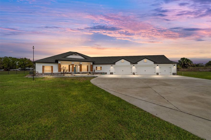 One or more photo(s) has been virtually staged. Welcome to your private 5-acre sanctuary in Fruitland Park! This 2021 custom-built estate seamlessly blends modern luxury with a true hobby-farm lifestyle. From the moment you pass through the private gate, you’ll be captivated by the sprawling, professionally managed grounds featuring dedicated rows for planting with a full irrigation system—perfect for a private vineyard, orchard, or organic garden. Inside, the home boasts over 3,100 sq. ft. of high-end finishes, including 10-foot ceilings, cedar-beamed tray details, and a gourmet chef’s kitchen anchored by two Quarts islands and a professional 6-burner Thor gas range. The living area opens completely to the outdoors via four retractable sliding glass doors, leading to a massive 52x44 screened lanai with a sparkling freeform saltwater pool, jetted spa, and Ponderosa Pine ceilings. The layout features two master suites, one of which includes a custom built in closet with a gun safe for added security. Built with efficiency in mind, the home features an insulated attic, a fully insulated garage, and an owned propane tank (no lease fees!), ensuring comfort and lower utility costs year-round. For the hobbyist, a detached 34x40 workshop offers ample space for an RV, boat, or car collection. This property is a rare find, offering the ultimate in craftsmanship, privacy, and agricultural potential.