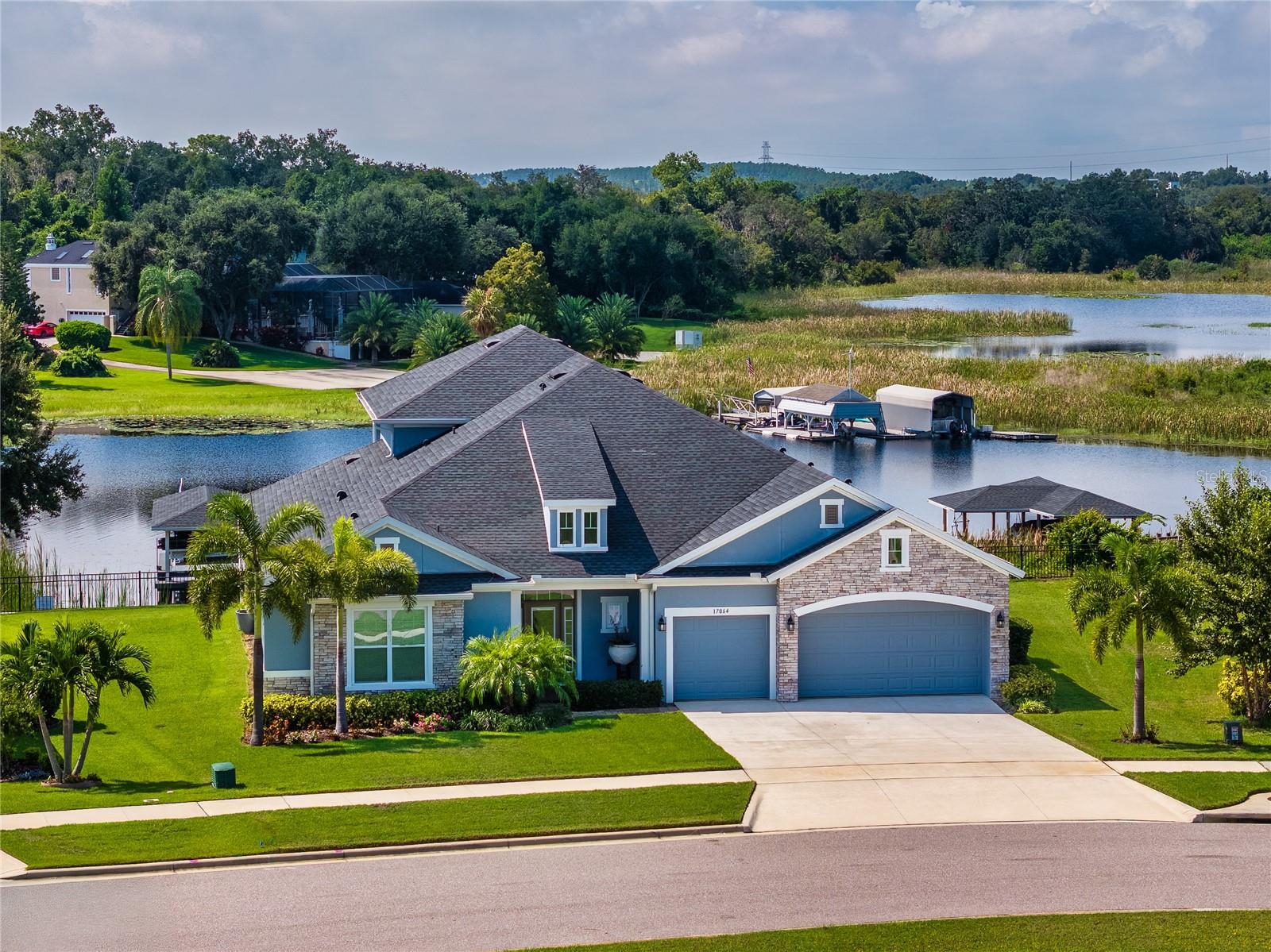 A rare opportunity to own a waterfront masterpiece in highly desirable community of Johns Lake Landing, nestled on the shores of Johns Lake—2,400-acre boat and ski lake ranked among Florida’s top 10 bass fishing destinations. Expansive view of the lake as you enter the home. This beautiful home maximizes the views of Johns Lake and is single-story with only a bonus room and full bath on second floor. This open concept luxury home delivers 4 bedrooms, 4.5 bathrooms, a game room, formal dining room, a study, a bonus room, a built-in desk area, and a 3-car garage with electric vehicle charger. The gourmet kitchen is open to a spacious family room. A great place to host the holiday dinners with the stainless-steel appliance package that includes built-in wall oven and microwave, induction oven and a range hood. The large island with quartz countertops is sure to be a favorite spot to a host who loves to cook and entertain. A sliding glass door off of the family room leads to a huge covered lanai that overlooks the lake. The entire 3,800+ SF home has level 5 wood-look tiles throughout except upstairs' bonus room which has wood flooring. Counter tops in kitchen and all bathrooms have level 4 quartz. Induction cooktop, high-power vent hood, and cat6 data connections throughout the house are just some other upgrades seller selected. Seller spent almost $200k on upgrades. Home is David Weekley's award winning floor plan Boulevard with 2nd story bonus room with a full bath and huge covered balcony which allows you to have a further view of the lake and conservation. Clermont is one of the fastest growing cities in Florida, close to historic downtown Winter Garden, nearby cycling, walking, jogging or skateboarding on the West Orange Trail, and less than three miles to public boat ramp on John's Lake, zoned to A+ rated schools and top-rated Montverde Academy is five miles away. You are close to all the actions i.e. Orlando's world famous attractions, SR 429, SR 50, FL Turnpike, shopping and entertainment, etc. Not sold yet? This home is sitting on an oversized 0.71 acre lot with 123-foot lake front facing south! What a way to watch the beautiful sunset in the comfort of your own home!