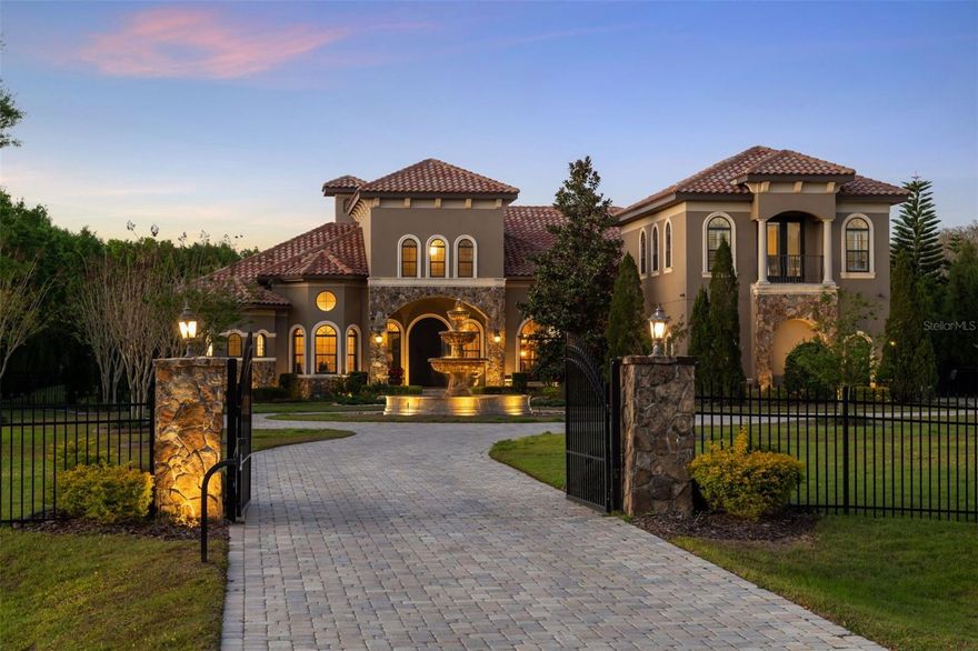 Welcome to 11207 Sunny Delight Court, an extraordinary Mediterranean-style masterpiece nestled within the gated community of Steeplechase. Prepare to be captivated by the exquisite craftsmanship, stunning architecture, extensive list of improvements, and unparalleled amenities that make this 2.35-acre property truly exceptional. Spanning over 8,800 square feet of living area (more than 6,640 square feet with air conditioning and heat), this stunning estate showcases six full bedrooms, five full bathrooms, and three half bathrooms that provides an abundance of space for family and guests. The 10-foot Brazilian door offers entry into the grand foyer with soaring 22-foot ceilings. The main level features a living room that beckons with its stone mantle gas fireplace that exudes warmth and sophistication. Host unforgettable dinner parties in the columned formal dining area or embrace your culinary aspirations in the chef's. The double island layout, dressed in exquisite granite, pairs seamlessly with top-of-the-line stainless steel appliances and a six-burner gas cooktop. This culinary haven is beautifully complemented by brilliant Brazilian cabinetry, providing ample storage space. For outdoor entertaining, step into the expansive summer that is ideally equipped to cook and entertain amidst the natural beauty of the surroundings. Here, you can relax and unwind as you overlook the enticing pool and spa area from the extra-large covered lanai. Indulge in a refreshing dip or unwind in the soothing waters of the heated pool and spa. Adorned with architectural lighting and surrounded by mature landscaping, the fenced-in 2.35-acre property ensures privacy and security while maintaining curb appeal. Indulge in the luxurious primary suite within this stunning residence that features hardwood floors and double closets. The ensuite bath is a sanctuary of relaxation, boasting granite countertops, a custom Jacuzzi with a center island, and a walk-around shower adorned with dual rainmaker shower heads. You'll also find an outdoor shower and pool bath, offering an indulgent al fresco bathing experience. Flexible living spaces abound in this home, including a spacious upstairs loft/bonus area with a half bath. Currently utilized as an office, this versatile space could easily be transformed into an in-law suite or a state-of-the-art movie theater room, catering to your personal preferences and needs. The north wing of the upper level encompasses two guest suites with ensuite baths and an elongated balcony with captivating conservation pond views. The south wing offers a media room with wainscoting and hardwood flooring, as well as a second study or exercise room. The seller has invested over $740,000 in upgrades and home improvements, ensuring that no detail has been overlooked. From the $65,000 custom Italian marble fountain and pool cage cover to the extended concrete slab and travertine pavers, every aspect of this home has been meticulously enhanced. Additional upgrades include a new washer, dryer, and refrigerator, as well as a fully upgraded outdoor kitchen with granite tops. The property also features a new A/C unit, LED lighting in the pool, and an entire home RO water filtration system that delivers restaurant-grade drinking water throughout the entire home. A reverse osmosis water system, full-house generator, and countless other features, this home truly represents the epitome of luxury living.