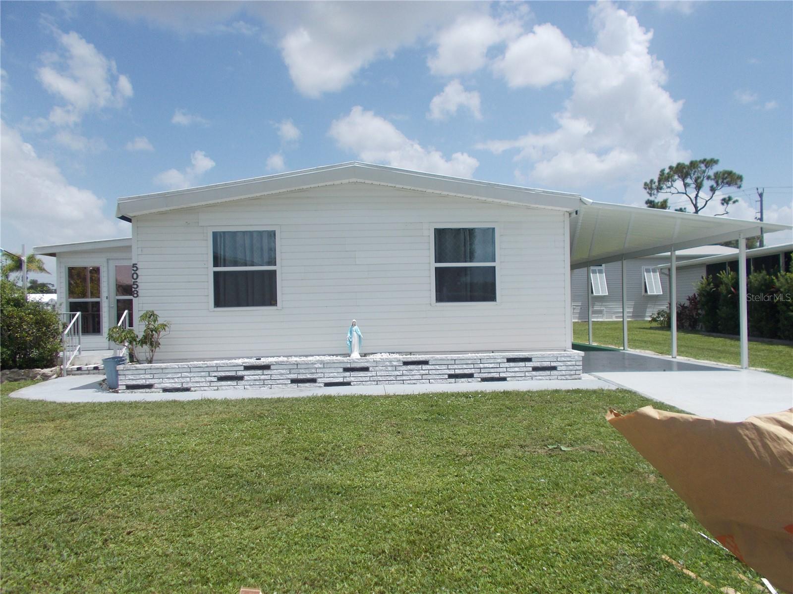 This is a 2 bedroom, 2 bath doublewide home located on a corner, in a cul-de-sac, in the 55+ Community of Holiday Park and in the PET SECTION. This home features laminate flooring in the living areas and newer appliances. The kitchen has plenty of cabinets for all your cooking needs. As per owner the roof and AC are 2023. You have a Florida Room off the Living Room for your entertaining needs. A large shed (11X27) has the washer and dryer. In Holiday Park you own the land with a deed and your monthly maintenance charge of $195.00 ($2340.00 a year) is included in your taxes. The community features 2 clubhouses, 2 swimming pools, a library, fitness center, tennis courts, pickle ball & bocce to name a few. You are close to shopping, dining, entertainment, numerous golf courses, sports facilities, airports and SW Florida's world renowned beaches. Come take a look!
