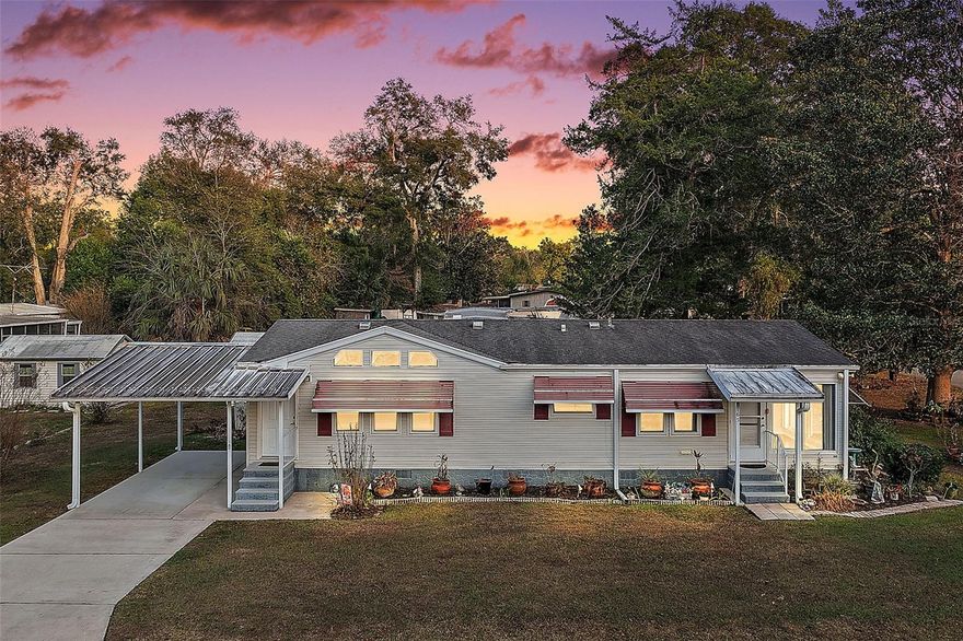 Welcome home to 9165 SW 32nd Ct. located in Ocala, Florida — the Horse Capital of the World! This beautifully maintained, single-owner double-wide manufactured home sitting on an oversized corner lot filled with mature trees, lush landscaping, colorful flowers, and visiting birds. From the front exterior, step inside to a bright and inviting living room featuring hardwood floors that flow through the main living areas and into the Florida room. The kitchen offers added storage with an updated re-design that relocated the washer and dryer from the pantry to a convenient, connected enclosed outside laundry room. Just beyond the living space, the Florida room and screened-in lanai create the perfect setting to relax with your morning coffee while enjoying peaceful backyard views and wildlife. The spacious primary suite includes a large closet, private en-suite bath with walk-in shower, and an attached bonus room ideal for a home office, sitting room, or hobby space. A comfortable second bedroom and full guest bath provide plenty of space for family or visitors. Outdoors, you’ll find a powered storage shed, hurricane shutters, and the added savings of a private well and septic system — plus the rare opportunity to own your land with NO LAND LEASE. Peacefully tucked away yet just minutes from the World Equestrian Center, major shopping, dining, and everyday conveniences — this home offers the perfect blend of privacy, charm, and location. Schedule your private showing today and come experience it for yourself!