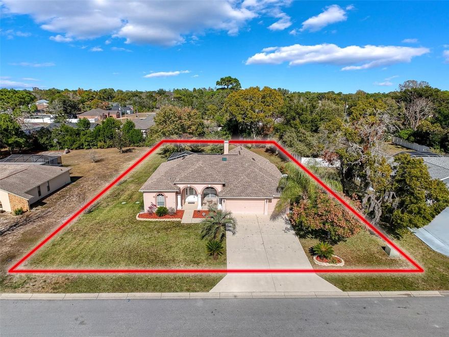 Welcome to Rainbow Woods — a beautifully maintained and highly desirable community in the heart of Spring Hill. Proudly owned by the original owner since construction, this exceptionally cared-for 4-bedroom, 3-bath pool home sits on a spacious ½-acre lot and boasts a long list of major updates already completed for you: a NEW roof (Sept 2024), NEW pool tile and Gunite finish (Nov 2025), NEW interior paint, NEW luxury vinyl plank flooring throughout most of the home (Nov 2025), tile in the kitchen and bathrooms, and a newer A/C system (Sept 2020). From top to bottom, the home reflects years of thoughtful upkeep and pride in ownership. 

 Step through the front door into a bright, welcoming family and dining room combination, filled with natural light from the wide 3-panel sliders that frame beautiful views of the sparkling pool. 

To the left, the expansive primary suite offers dual closets, a large ensuite with dual sinks, a soaking tub, and a separate shower. A private slider off the bedroom opens directly to the pool—perfect for quiet morning coffee or evening relaxation. 

 Through the family room, an elegant arched entry leads into the sunny breakfast nook and well-appointed kitchen, featuring stainless steel appliances, stunning white showcase cabinetry, extensive built-in storage, a high bar for additional seating, and abundant counter space ideal for cooking and entertaining. The kitchen flows seamlessly into the inviting living room, complete with a cozy wood burning fireplace and beautiful new luxury vinyl floors. 

 Just behind the living room lies a large bedroom paired with the pool bath, offering an ideal in-law or guest-suite style setup. With its direct pool access, this area provides privacy, convenience, and versatility for extended family or visitors. 

 Off the living room are two additional spacious bedrooms with a full bathroom between them. One room features elegant double-entry doors, and both enjoy excellent natural light, giving this wing of the home an open, comfortable feel. 

 Past the kitchen toward the front of the house is a convenient pantry and a tidy laundry room with a utility sink. A skylight-lit hallway leads to the oversized freshly painted 2½-car garage, providing excellent storage, workspace, or room for larger vehicles. 

 Step outside to your private Florida oasis: a screened-in pool freshly updated in 2025, a large covered sitting area with new dual ceiling fans, and lush mature landscaping that wraps the entire ½-acre lot. This outdoor retreat is perfect for entertaining, relaxing, and enjoying Florida living year-round. 

 With its thoughtful updates, meticulously maintained condition, and incredible layout, this one-owner home is a true gem nestled within the sought-after Rainbow Woods community.