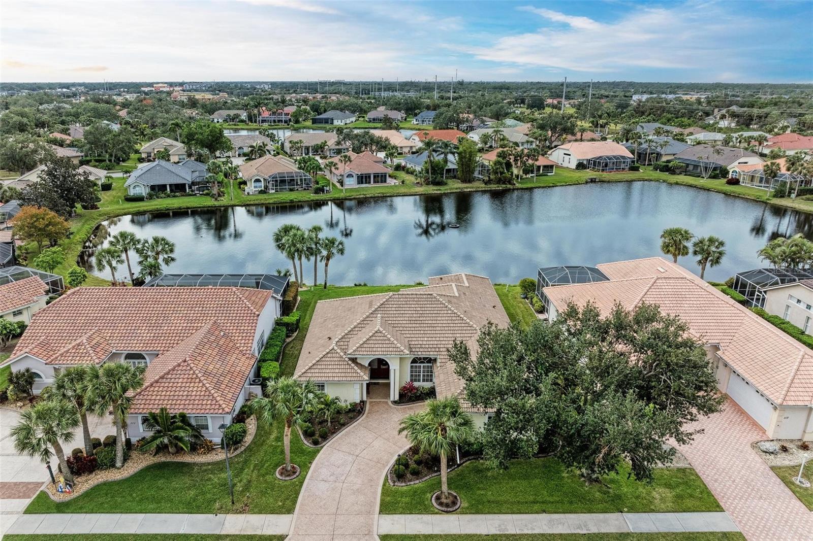 Welcome to 115 Grand Oak Circle, an entirely newly painted (2024) stunning 3-bedroom, 3-bathroom home with a den and NEW roof (2024), nestled in the desirable Hidden Lake Club of Venice, FL. This modern retreat offers 2,365 square feet of luxurious living space with OVER $80,000 in upgrades. As you enter through the elegant French doors, you're greeted by a formal dining room and sitting area. The sliding doors in this space draw your eyes beyond, offering captivating water views of the serene lake. The home features high ceilings and elegant tile flooring throughout, with NEWER luxury vinyl flooring (2019) adding a touch of warmth to the dining and sitting rooms, as well as the bedrooms. The open-concept FULLY RENOVATED kitchen (2021) and living room are a chef's dream, featuring new granite countertops, new oak cabinets, and crown molding that add a touch of sophistication to the space. The master suite is a true sanctuary, located on the left wing of the home. It boasts dual sinks, a walk-in shower, a soaking tub, and two generous closet spaces. On the right side of the home, just off the family room, you'll find two additional bedrooms and a shared bathroom, providing privacy and convenience for family or guests. Beyond the family room, discover a cozy den and a full bathroom, perfect for a home office or guest suite. The pocket doors throughout the home offer privacy without compromising the open feel of the space. Step outside to the newly screened-in lanai (2019), where you can relax and enjoy breathtaking views of the lake and lush greenery. This outdoor oasis features a hot tub (2017), perfect for unwinding after a long day, and a newly added nonskid flooring (2022). The expansive 9,150 square foot lot provides plenty of space for outdoor activities and entertaining. Additional upgrades include a NEWER AC and water heater (2021) and a Culligan water softener. Living in Hidden Lake Club means enjoying a year-round heated pool and spa, a fitness center, a library, and a clubhouse with a usable area for private parties. The community also offers bocce ball, shuffleboard, basketball, and tennis/pickleball courts. Conveniently located, this home provides easy access to local amenities, shopping, dining, and the beautiful beaches of Venice. Don't miss your chance to make 115 Grand Oak Circle your new home!