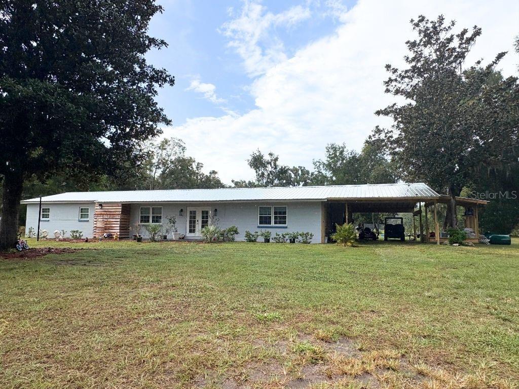 Welcome to this beautifully renovated 4-bedroom, 3-bathroom home, set on 7.46 acres of cleared land. This spacious property offers the ideal mix of country living and modern convenience, providing ample space for those who want to raise livestock, start a hobby farm, or simply enjoy the peaceful privacy of rural life. The brand-new attached carport measures approximately 20' x 29', perfect for storing your tractor, lawn equipment, vehicle, or anything else you want to keep protected from the elements. Inside, you'll find a bright, open floor plan that seamlessly blends comfort and style with a newly updated kitchen featuring stainless steel appliances, plenty of counter space, and a design perfect for gatherings. The primary suite offers a private retreat to unwind at the end of the day. Recent updates include a new well, and fresh fans and light fixtures throughout, ensuring that this home is ready for its next owner. Outside, the expansive backyard features a large patio and built-in bar, ideal for relaxing or entertaining. With direct access to local springs and rivers, this property is perfect for outdoor enthusiasts. Explore the crystal-clear waters of Ginnie Springs, Poe Springs, and Gilchrist Blue Springs, where you can swim, snorkel, or dive in 72-degree water year-round. Paddle or fish the scenic Santa Fe and Ichetucknee Rivers, which are perfect for kayaking, canoeing, tubing, or fishing. For hiking and biking lovers, over 35 miles of trails await you at River Rise Preserve and O’Leno State Park. When you're ready to explore the charm of downtown High Springs, you'll find antique shops, cozy cafés, and the local favorite Great Outdoors Restaurant, serving fresh, locally sourced dishes. Plus, for craft beer lovers, you’ll enjoy direct access to High Springs Brewing Co., part of the Sippin' Seven Alachua County Ale Trail, accessible via an abandoned railroad track. With privacy, acreage, and modern updates, this home is ready to become your personal retreat. Schedule your private showing today!