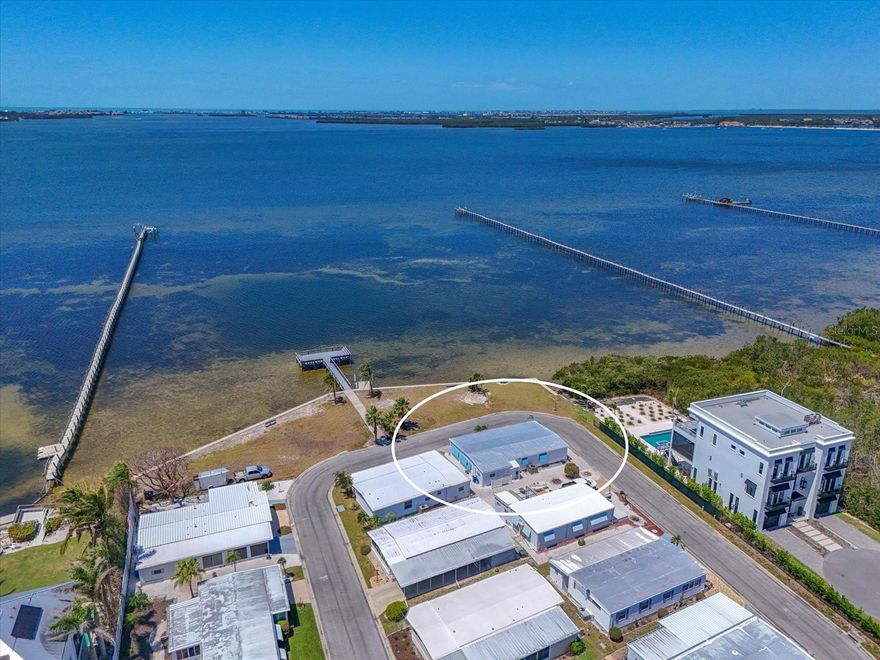 Amazing value for this Palma Sola Shores waterfront gem!  This fully remodeled and almost turnkey furnished 2 bedroom/2 bath manufactured home is truly one of a kind and you will not want to miss out on this rare opportunity!  There are only two properties in Palma Sola Shores with full, unobstructed views of Palma Sola Bay and this is your chance to own a piece of paradise!  This property was fully remodeled by the current owners in 2020 and offers high-end updates from top to bottom and stunning bay views.  Nothing compares to the quality found here and once you have the opportunity to view you will agree!  The spacious and open layout offers luxury vinyl plank flooring throughout the living area and new carpet in the bedrooms. You will also find all new subfloors, new 2025 electrical supply, plumbing, new interior doors and hardware, new insulation and vapor barrier (Feb.2025) and a new 3 1/2 ton York A/C packaged unit with all new duct work and surge protection.  You will simply fall in love with how pristine this home is both inside and out with new exterior paint, recoated roof with Sherwin Williams Uniflex aluminum sealant, newly installed Bahama shutters and new landscaping outside.  The kitchen is a true showstopper with Schuler custome cabinetry, granite countertops, stainless sink, Jeffrey Alexander counter island with granite top, glass tile backsplash and gorgeous stainless fingerprint free appliances. Both updated bathrooms feature premium finishes, faucets, lighting and toilets with slow close seats. Another amazing plus is the huge Florida room with seamless 4-panel screen and accordian security shutter where you can enjoy entertaining many guests here while taking in the gorgeous bay views. Motorized hurricane shutters in the front of the house for extra peace of mind. 2025 washer and dryer along with side by side stainless fridge with ice-maker in your spacious laundry room.  New outside shower with privacy fence and dressing room for when you come home from the nearby beaches found on Anna Maria Island is another added feature.  Located in the desirable 55+ community of Palma Sola Shores this gem is absolutely move in ready and adorn with high end furnishings and decor making it perfect for year round living or a seasonal retreat. You can enjoy the community ammenties of the heated pool, shuffleboard courts, clubhouse, kayaking or fishing from the community dock or watch the dolphins and Florida birds at play.  Short drive to Anna Maria Island where you can enjoy the white sandy beaches or restaurants and also conveniently located to local shopping and ammenities.  Come experience the charm, comfort and coastal beauty found here before this opportunity is gone! Palma Sola Shores is a land owned community with low monthly maintenance fees that even include your water, cable and internet. Sorry, no pets, golf carts, motorcycles or rentals allowed at this community.