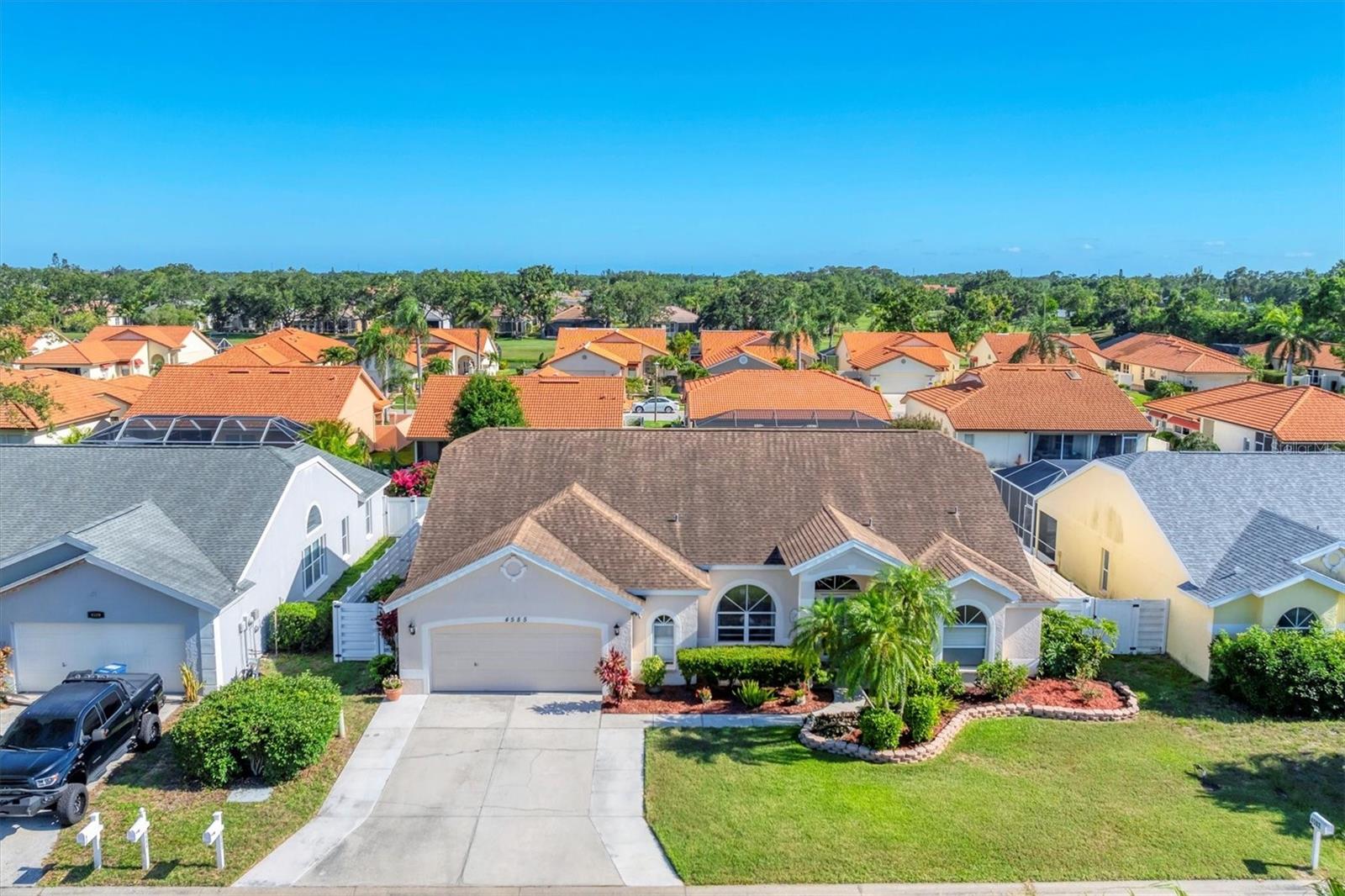 **Back on market due to no fault of the property or seller. Buyer withdrew after a personal situation arose unrelated to the transaction.** Experience the best of Florida living in this thoughtfully updated three bedroom, two bath pool home that blends everyday comfort with elevated design. Volume ceilings soaring to 18 feet create a bright, open atmosphere the moment you walk through the door. The kitchen is as functional as it is stylish, featuring granite countertops, soft-close cabinetry, newer stainless steel appliances, and a cafe area with built-in bar and an aquarium window. Just off the kitchen, a family room offers an easy flow for entertaining or relaxed nights in. Formal living and dining spaces with laminate flooring provide flexibility for gatherings large or small. The split-bedroom layout ensures privacy, with the owner’s suite offering marble floors, a walk-in closet, and direct access to the pool. The en-suite bath includes a double vanity, soaking tub, and walk-in shower, your own private retreat. The two additional bedrooms are served by a full bath that also functions as a convenient pool bath. Step outside to your private backyard oasis. The southern-facing pool is perfect for sunny afternoons, complete with new tile, travertine decking, a peaceful water feature, and a sun shelf ideal for lounging with an umbrella. Additional features include an expanded laundry room with sink and storage, central vacuum system, and a widened driveway with 8 extra feet for added parking. This home offers the space, layout, and amenities to enjoy life, indoors and out, with style and ease.