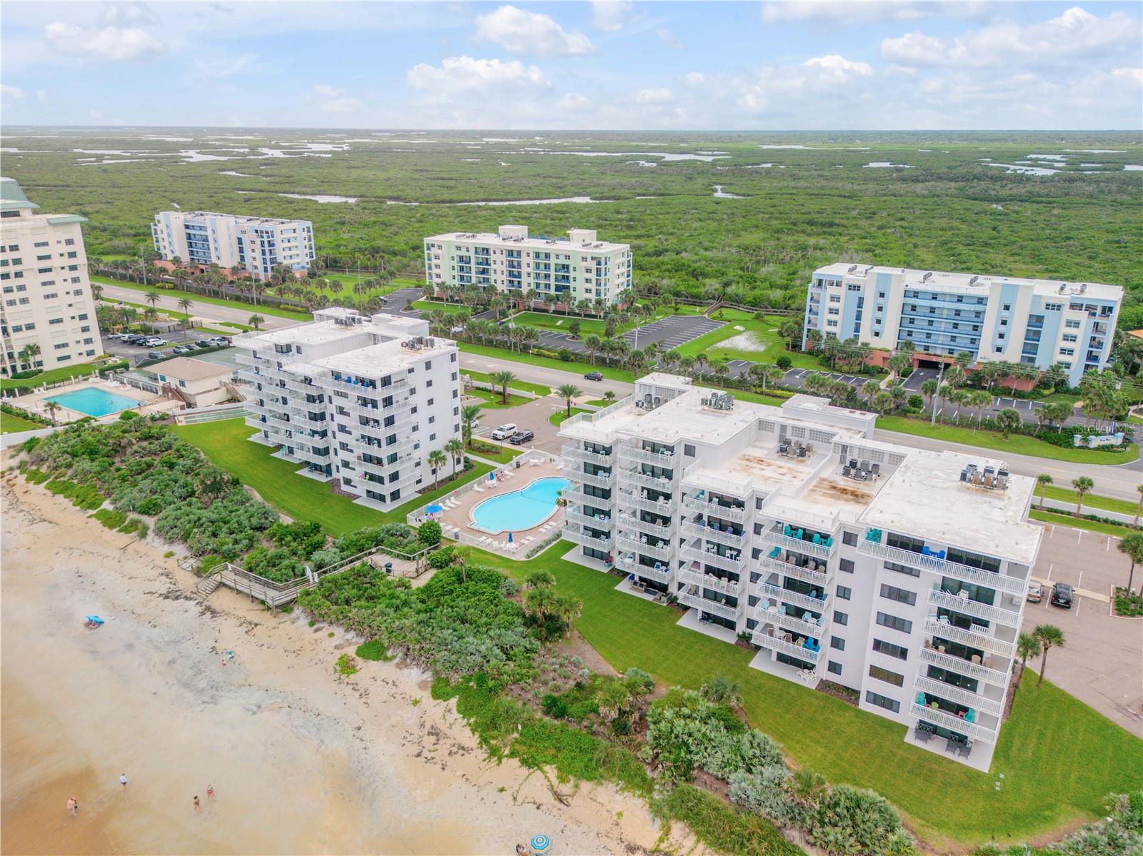 Welcome to Shoreham by the Sea, a beautifully maintained oceanfront condo community located directly on the no-drive beach in New Smyrna Beach. This fully furnished 2 bedroom, 2 bathroom corner unit offers prime ocean views and an open, light and bright floor plan perfect for coastal living. The stunning remodeled kitchen features solid surface countertops, stainless steel appliances, and stylish finishes. Recent interior updates include a new couch and loveseat, washer and dryer, bunk beds, patio furniture, A/C unit, and barstool chairs—ready for immediate enjoyment or rental. Shoreham by the Sea allows weekly rentals, giving you the flexibility to make this your new beach condo home or a strong investment property with great income potential. The complex has undergone extensive renovations, including total stucco repair and exterior painting, a new balcony, remodeled elevator system, refurbished pool and restrooms, and a freshly repaired and repainted parking lot. A 165,000k assessment has been fully paid by the seller, unlike many other units still undergoing assessments to comply with Florida’s new laws. All reserve funding and state-required updates have been completed, giving you peace of mind. Enjoy being just minutes from shopping, dining, and all that New Smyrna Beach has to offer in this move-in-ready oceanfront gem! Schedule your showing today!