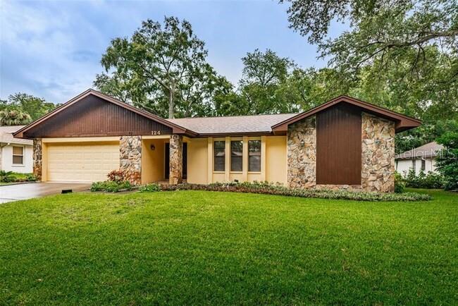 Very nice updated home with beautiful wood floors throughout, a two car garage and lots of living space! You'll also find plenty of room in this home: large living room, separate dining area, kitchen with updated cabinets, pantry cabinets, stone surfaces & all appliances. The kitchen is open to the family room for family time and gathering. Split bedroom plan with primary bedroom featuring an ensuite bath and walk-in closet. Two other bedrooms and large bathroom located off the family room, and separate laundry room which includes the washer & dryer. Oversized back screened patio extends your living space. The large back yard is surrounded with a partial fence and trees. The neighborhood is quiet BUT located just off Tampa Rd and near US-19, retail, shopping and beaches. Home is offered with the existing furniture, or furniture can be removed. Lawn service is included.