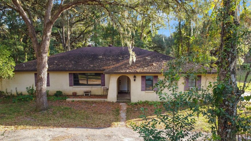 With some imagination and elbow grease, this ranch-style abode could be transformed into the perfect urban homestead! Tranquility is the name of the game; it sits on 5 fully fenced and cross-fenced acres on a close-ended road with no through traffic in beautiful rural Brooksville with no deed restrictions or HOAs. Majestic grandfather oaks draped with Spanish moss dot the landscape, and there’s even a seasonal pond at the very back of the property. Inside, the split-bedroom floor plan features real hardwood flooring and a lovely wood-burning fireplace in the cozy family room. A formal dining room and a sunken living room offer plenty of space to entertain. The kitchen is open with lots of counter space for prep work, cabinet space for storage, and a breakfast bar overlooking a large eating nook. There’s an enormous walk-in closet in the primary bedroom; the ensuite bathroom has a step-in shower. The remaining two guest bedrooms have sizable closets. They share a bathroom with dual sinks and a tub/shower combo. Park your grill on the vinyl-enclosed Florida room for summer barbecuing, or simply sit on a rocker with a pitcher of sweet tea and enjoy the sounds of the abundant bird and wildlife population. And since it’s zoned AG, you can bring your feathered and furred friends, too! The 24’x60’ pole barn equipped with power and water has horse stalls plus a large storage/tack room for your animals’ needs. If you don’t want to create your own garden, you’re only about a mile away from Beasley Farm, where you can pick up locally-grown produce and other goods. Located minutes from the 157,000 acre Withlacoochee State Forest, you’ll find tons of options for outdoors enthusiasts nearby, including the Croom Motorcycle Area, the Good Neighbor Bike Trail, campgrounds, horse riding trails, hiking trails, and more. The charm of downtown Brooksville with its mom-and-pop shops and restaurants is a short drive southwest. You’re also conveniently situated between I-75 and US-41, so travel to Tampa is accessible. If you’ve got the time and the love to invest, this home could be everything you’ve ever dreamed of and then some. Get started on making that dream a reality by scheduling your private tour today!