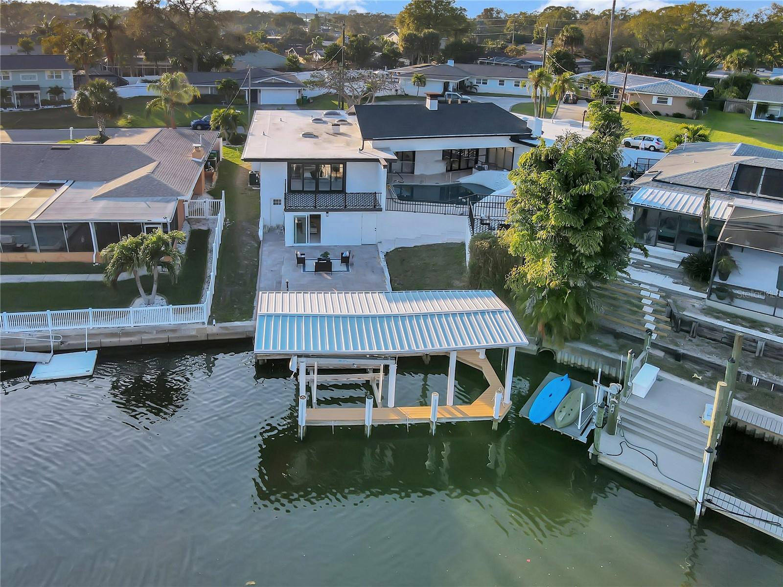 Under contract-accepting backup offers. Coastal elegance meets contemporary chic in this fully renovated, WATERFRONT, 4 bedroom, 3 bathroom pool home PLUS mother-in-law suite in the highly sought after Harbor Hills neighborhood. This home offers 85 feet of upscale, waterfront living. Brand new tropical landscaping welcomes you. As you step inside you will enjoy sophisticated updates including stunning, coquina shell stucco interior, accent walls. Enjoy sweeping water and pool views in the chef’s kitchen. A few highlights of the designer kitchen are the Bianco Cielo quartz countertops, chef's range and hood, dual zone wine and beverage fridge, under counter ice maker and convection microwave drawer. The kitchen offers countertop and island seating for six. Entertaining is a breeze as the kitchen opens up to a dining room which overlooks the great room. The spacious master retreat features two sets of sliders – one set opens onto the pool deck and the other onto a patio space overlooking your waterfront oasis. The ensuite bathroom features a fantastic walk-in shower and stylish black & white tile work throughout. There are three additional bedrooms, two more full bathrooms, a wood-burning fireplace and interior laundry on the main floor. Outside you will enjoy the pool, a covered patio space perfect for al fresco dining and an open air deck for your lounge chairs. A covered dock and 10K boat lift is yet another perk. Below the main house is a mother-in-law suite or home office. Its amenities include a fully updated kitchen, family room, bathroom and over-sized closet. 85 feet of waterfront provides quick access to the intracoastal waterway and warm Gulf waters. Not to be forgotten is the brand new TPO membrane roof. SHORT TERM RENTALS ARE ALLOWED. All this and you are in close proximity to dining, shopping, the famous Belleair Country Club and award-winning Gulf beaches. The Tampa International and St. Pete airports are only 20-30 minutes away. Inside and out, this is a complete waterfront gem!