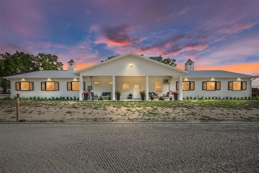 EXCEPTIONAL EQUESTRIAN ESTATE
Positioned directly across from the renowned World Equestrian Center in the heart of Ocala, Florida — the Horse Capital of the World — this extraordinary estate represents a rare opportunity to own a world-class equestrian property at the epicenter of the sport.
Equestrian Facilities
The barn and riding arena were custom built in 2025 by Jim Ballinger of M&W Building Solutions, reflecting the highest standards of craftsmanship and equestrian design. Constructed of solid cinderblock with a double-insulated roof and French drain gutters, the barn is engineered to handle Florida's heavy rainfall while keeping the interior dry and comfortable year-round.
The professional-grade barn features 12 spacious 12' x 14' stalls, each equipped with individual fans, fly spray systems, and automatic waterers. Three cupolas and large industrial overhead fans ensure exceptional airflow throughout. Yoke windows along the aisle and exterior shuttered windows flood the space with natural light while maintaining a classic equestrian aesthetic. Two roll-up end doors and a euro-style slide entrance add everyday convenience for equipment, hay delivery, and vehicle access. The barn is further appointed with two interior wash racks with hot and cold water, a tack room, feed room, laundry room, bathroom, and kitchenette.
Riding Arena & Paddocks
The impressive 150' x 250' all-weather riding arena features a full irrigation system and concrete curb, providing premier footing year-round. Two interconnected water wells — including a dedicated 5 HP well powering arena irrigation — ensure a reliable water supply at all times. Seven irrigated paddocks, freshly reseeded and fully fenced with hot-wired fence boards, offer safe, lush turnout for your entire herd.
Residential Accommodations
The main residence offers 6 bedrooms and 3.5 bathrooms, completely remodeled in 2025 — professionally decorated and furnished by an interior designer with all new appliances — delivering generous spaces for everyday comfort and entertaining. Bedroom views overlooking the barn, arena, and paddocks offer a truly immersive equestrian living experience. Beautifully appointed patio areas extend living space outdoors, perfect for relaxing while taking in the serene surroundings. A newly installed gated entrance and paved parking area offer security and a polished first impression. Multiple dwelling units provide flexibility — ideal for guest quarters, staff housing, multigenerational living, or income-producing opportunities.
Expansion Opportunity
Favorable zoning presents exciting possibilities — including the ability to build an additional residence, plus dedicated structures for hay storage and equipment. Whether expanding the operation or creating a multigenerational compound, the groundwork is already in place.
Location
At the heart of Ocala's premier equestrian corridor, this estate places you steps from the World Equestrian Center — whether you're an active competitor, dedicated breeder, or someone who appreciates the finest in equestrian living, this location puts you at the center of it all.