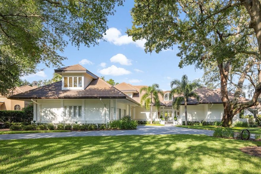 This serene estate sits among sprawling trees along the back nine of Isleworth’s championship golf course. As you step through the French doors, the formal living room beckons with an infusion of natural radiance, complemented by a dual-sided fireplace and floor-to-ceiling windows. The interconnected kitchen, family room, breakfast nook, and bar area showcase exquisite hardwood floors, accentuated by one of the two staircases leading to the upper level. Adjacent to the formal dining room, the kitchen presents a central island, a custom-paneled refrigerator, stainless steel appliances, and a generously proportioned walk-in pantry. The primary suite encompasses a secluded sitting area, a home office, and an en-suite bathroom adorned with dual vanities, a walk-in shower, and multiple storage closets. Ascending to the second level reveals three bedroom suites and a spacious landing boasting a built-in desk. Additionally, this level encompasses a versatile bonus space or entertainment room above the garage, complete with a powder bathroom. Engineered with ample storage solutions, the residence incorporates several expansive storage closets equipped with built-in shelving, catering perfectly to the safekeeping of seasonal decorations and more. Crafted to be an entertainer's haven, the screened lanai provides a vantage point over the glistening pool and verdant landscaping meticulously designed to ensure privacy.