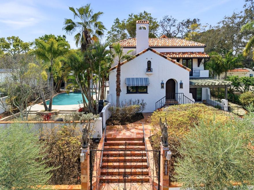 Step into a private Mediterranean-inspired retreat in the heart of Clearwater. This rare and timeless estate blends 1920s architectural charm with modern luxury, offering an expansive layout, resort-style amenities, and unforgettable outdoor living. Behind custom gates, the home opens to warm stucco textures, handcrafted details, and generous natural light. The main residence features spacious living areas, a grand primary suite, and beautifully updated finishes that honor the home’s original character while elevating its sophistication.  At the rear of the property, a beautifully designed mother-in-law suite with its own private entrance offers exceptional versatility. Ideal for extended family, long-term guests, or a secluded home office, this suite enhances the estate’s functionality while maintaining privacy for everyone. Outside, the property transforms into a true sanctuary. A tropical grotto-style pool with waterfall and spa anchors the lush backyard, creating a serene backdrop for both quiet mornings and lively gatherings. The added pool house provides flexible space for guests, a studio, or a private retreat steps from the water. Entertaining reaches a new level with the custom outdoor kitchen, thoughtfully designed with premium materials and ample prep space. Whether hosting intimate dinners or large celebrations, this outdoor haven delivers the ambiance of a boutique resort. Located minutes from Clearwater’s award-winning beaches, vibrant downtown, and top schools, this estate offers a rare blend of privacy, character, and luxury living. Truly a one-of-a-kind luxury property!