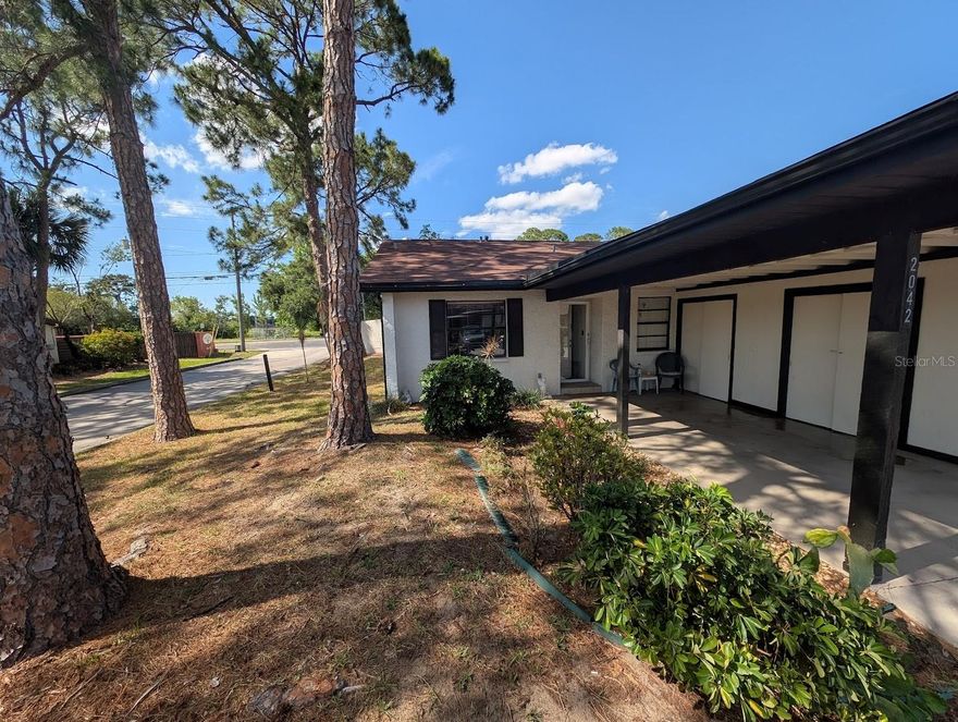 PRIME END-UNIT VILLA WITH EXPANSIVE PRIVATE YARD.  Plus a LOW HOA FEE of only $26 per month with NO CDD and NO FLOOD ZONE (X) designation for total peace of mind.  Meticulously maintained 2-bedroom, 2-bathroom end-unit villa perfectly situated in a PRIME LOCATION near the entrance of the tranquil Villas of Sunset Grove community.  This rare corner lot features an oversized private yard that offers a sense of tranquility and the privacy of having NO REAR NEIGHBORS.  The property includes an oversized carport that allows for a covered front porch adjacent to the front of the home.  Inside, the great room boasts SOARING VAULTED CEILINGS and plenty of natural daylight that highlights the clean, open layout.  The spacious, bright kitchen is a standout, featuring a convenient breakfast bar, solid wood cabinets, and a separate dining area, alongside the benefit of an INSIDE LAUNDRY room with the washer and dryer included.  Relax on your LARGE SCREENED REAR PORCH while enjoying the Florida breeze.  This central location offers easy access to Tampa and the airport and is just a short drive to vibrant DOWNTOWN DUNEDIN, downtown Safety Harbor, and the world-famous sands of HONEYMOON ISLAND and Clearwater Beach.  Residents also enjoy close proximity to local restaurants, parks, Publix, Target, Starbucks, COUNTRYSIDE MALL, and the Barnes & Noble bookstore.  The community pool is very luxurious and is available for an optional $450 per year fee.  Note that the HOA Fee to Sunset Grove Villas is paid as 1 payment per year of $317!  (which is $26.42 per month)