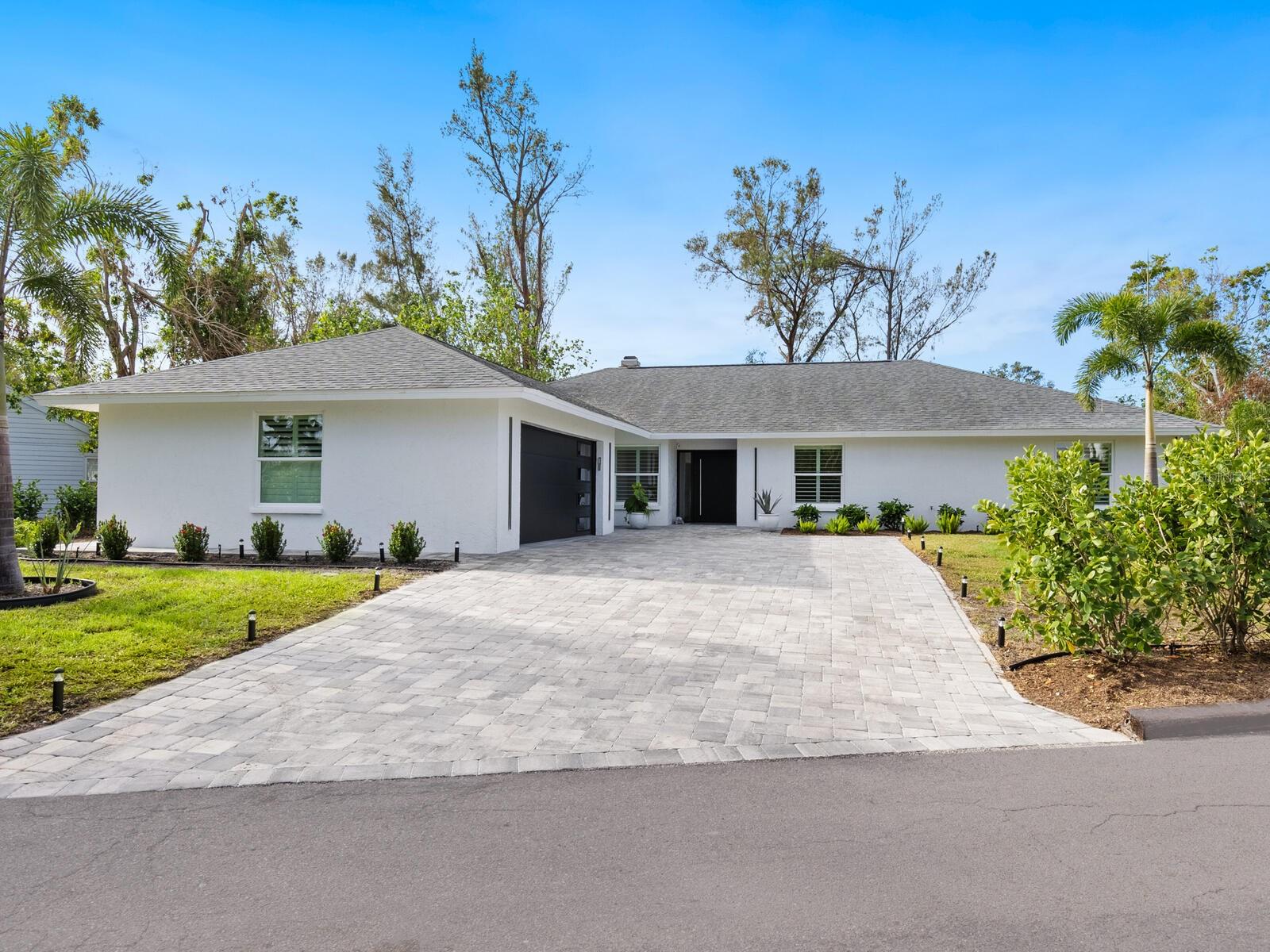 Siesta Key sanctuary, a coastal retreat with modern luxury. Discover a private tropical paradise in this contemporary, renovated four-bedroom, 2.5-bath pool home, ideally on nearly half an acre in one of Siesta Key’s sought-after communities. Designed with elegance and ease in mind, this stunning concrete block residence blends timeless charm with modern upgrades, offering the ultimate coastal lifestyle just minutes from the island’s famous white-sand beaches and vibrant Siesta Village. Step inside and be captivated by the open, light-filled layout, where impact glass windows bring in the outdoors. The heart of the home is a showstopping island kitchen featuring a gorgeous, reclaimed oak center island, handmade tile backsplash, quartz countertops and coordinating reclaimed oak open shelving. Abundant storage, including an entire pantry storage wall, ensures style and functionality. Designed for seamless indoor-outdoor living, this 2,598-air-conditioned square-foot retreat boasts an oversized living space that flows effortlessly into private tropical gardens. The expansive screened lanai leads to a tranquil backyard oasis with a newly renovated pool, paver deck, and lush landscaping, ideal for entertaining or unwinding under the Florida sun. The primary suite is a sanctuary, featuring a spa-like bath with designer finishes. Three additional bedrooms provide ample space for family and guests, while a flexible floor plan allows for a home office or den to suit your lifestyle. Further highlights include a full interior laundry room, a two-car garage, and plenty of storage. Meticulously reimagined by the contractor-owner for his own family, this 2023 renovation includes new kitchen and appliances, new baths, updated air conditioning and ductwork, new water heater and plumbing updates, renovated pool with new heater, pump and filter, and a paver driveway and pool deck. With no flood or hurricane damage, according to the owner, this home is a rare find, offering peace of mind and low-maintenance coastal living in an unbeatable location. Just a short drive to downtown Sarasota’s arts, dining and entertainment, this island retreat is an opportunity you don’t want to miss. Schedule your private tour today and experience the best of Siesta Key living!