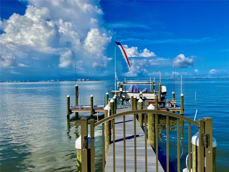 “Coastal Elegance on Sarasota Bay” Discover unparalleled coastal living with this custom 3,000 square foot Waterfront home with 20,000 sf of land and 100 ft of Sarasota Bay frontage offering one of the most incredible 180-degree views of the Bay. Built in 2019, to highest wind code standards this one story Coastal Architectural-Style gem blends modern luxury with timeless charm, offering 4 spacious bedrooms and 4 ½ beautifully designed bathrooms. Due to a home site elevation at 14 ft flood Insurance is optional. One of the few Sarasota Bayfront communities that experienced No Flooding during the 2024 Hurricane Season. Great potential for vacation rental. Step inside to experience an open and airy floor plan, accentuated by lofty t & g Cypress ceilings and expansive impact windows that frame breathtaking bay views. The living area flows seamlessly into a gourmet kitchen, featuring top-of-the-line appliances, custom cabinetry, and a large island perfect for both casual dining and entertainment, The primary suite is a luxurious retreat overlooking the water featuring his and her separate bathrooms and walk in closets. Each additional bedroom is oversized, ensuring comfort and privacy for family and guests. This home is built for outdoor living, offering a roomy, screened lanai with a heated pool and spa, plus a dining area that is perfect for taking in Sarasota’s sunsets. A private dock and boat lift for easy access to the bay for boating and water activities with no bridges to the Gulf. Additional features include an oversized 3 car garage, 7,500 lb boat lift, whole house backup generator offering peace of mind and added convenience. Located in sought after West of Trail Historic Ballentine Manor within proximity to Colleges, the IMG Academy, SRQ Airport, fine dining, shopping, and cultural attractions. This coastal retreat offers both luxury and practicality. Voluntary HOA $35/Year offers Culinary Membership to Historic Sara Bay Country Club. Do not miss your chance to own this exceptional Sarasota Bay Waterfront Home. Schedule your private tour today and experience the epitome of coastal elegance!